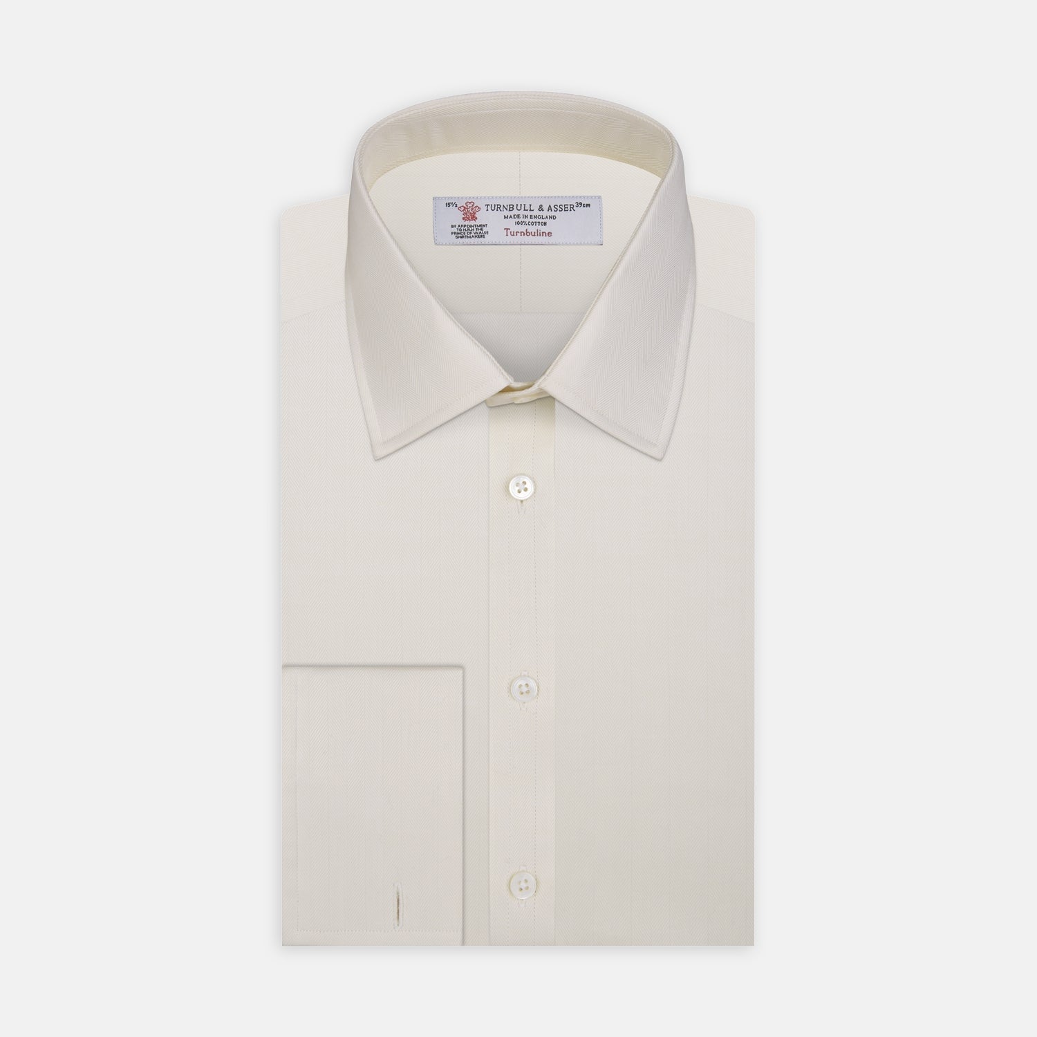 View 1 of product The Turnbull & Asser Cream Herringbone Superfine Cotton Shirt features a T&A collar, double cuffs, and a subtle pattern. It is neatly folded with white buttons and displayed on a plain white background.