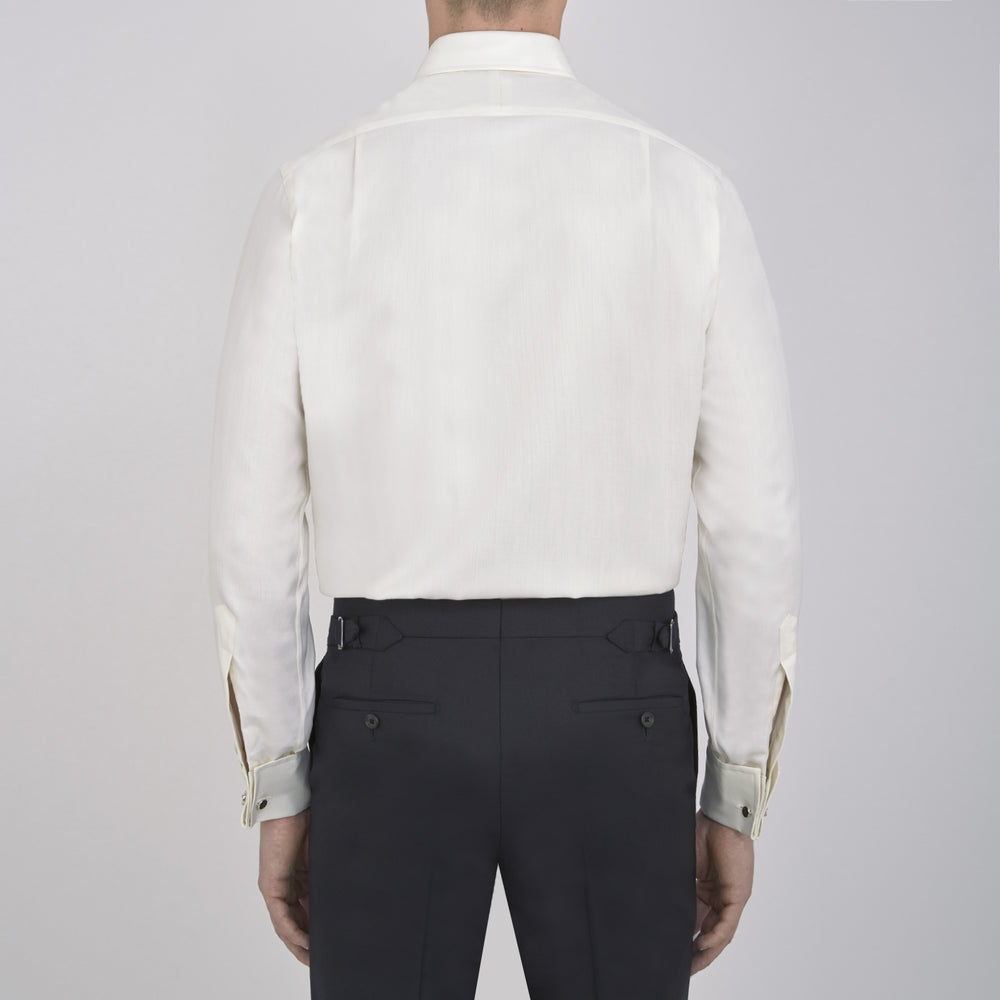 The Turnbull & Asser Cream Herringbone Superfine Cotton Shirt features a T&A collar, double cuffs, and a subtle pattern. It is neatly folded with white buttons and displayed on a plain white background.