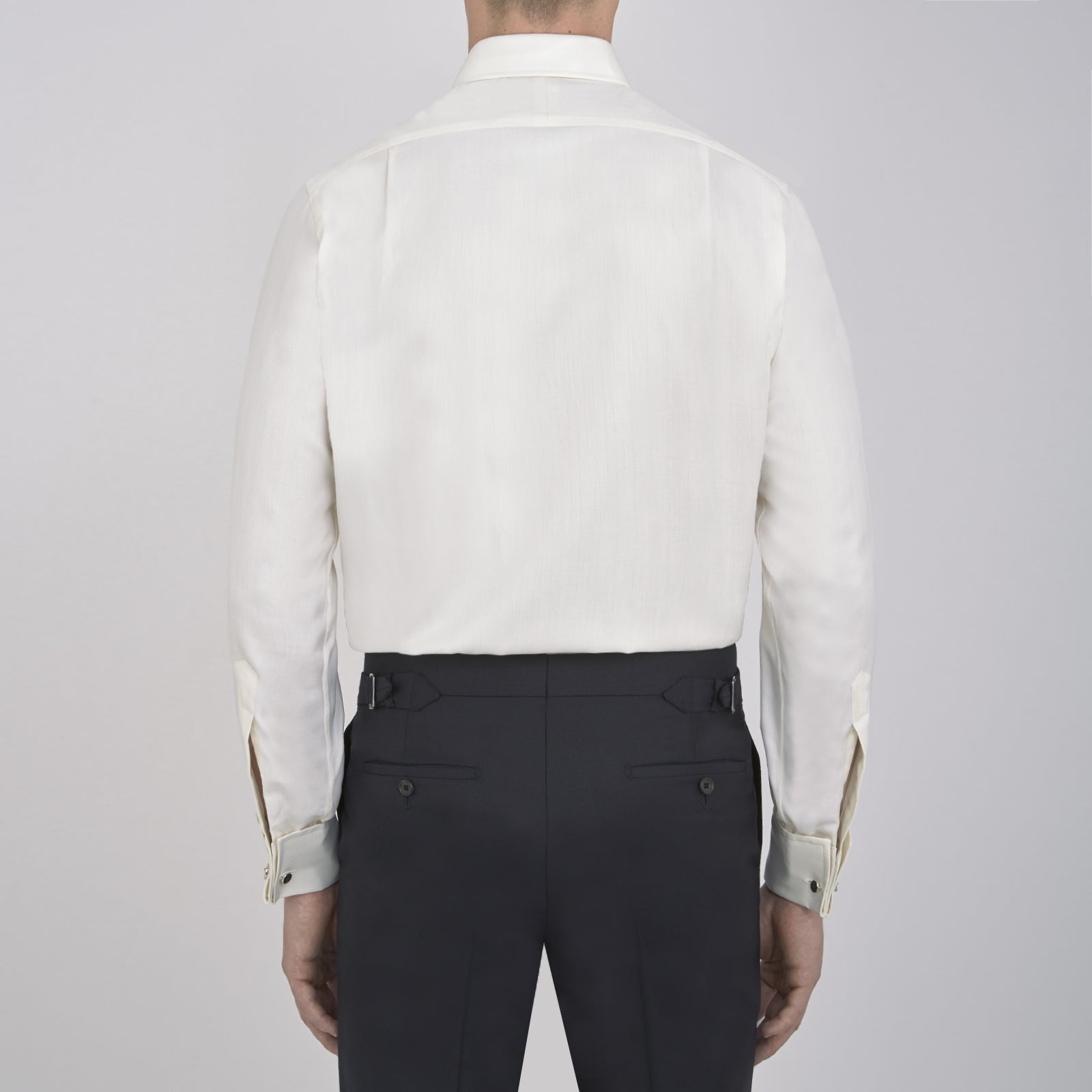 View 3 of product The Turnbull & Asser Cream Herringbone Superfine Cotton Shirt features a T&A collar, double cuffs, and a subtle pattern. It is neatly folded with white buttons and displayed on a plain white background.