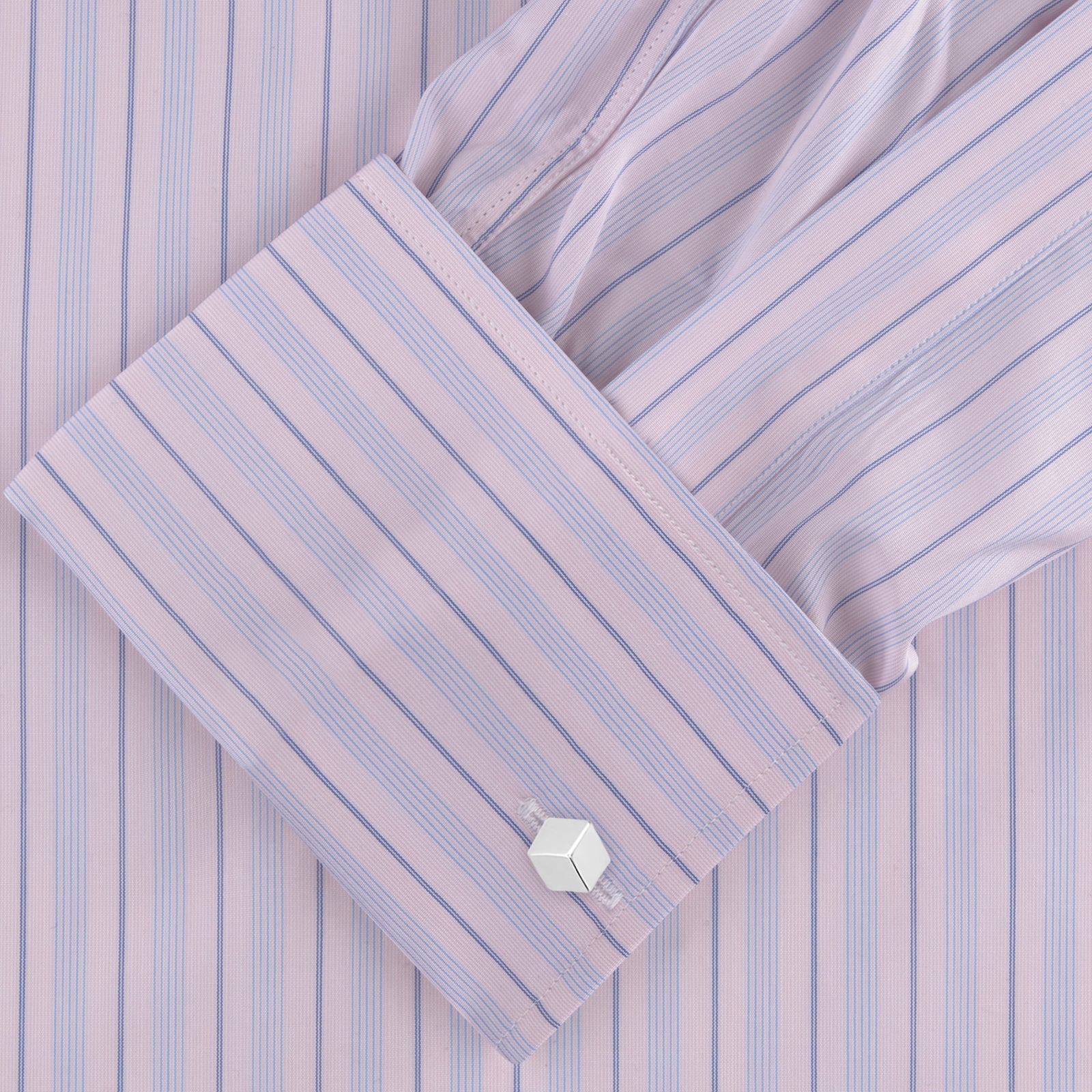 View 2 of product The Pink and Blue Mixed Stripe Shirt by Turnbull & Asser features a T&A collar, double cuffs, and white buttons—perfect for fans of colourful shirts—shown neatly folded against a plain white background.