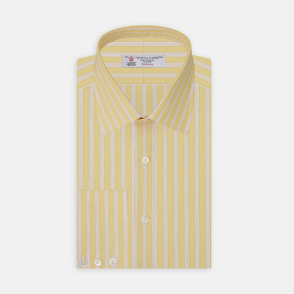 The Turnbull & Asser Yellow and White Bold Stripe Shirt features a T&A collar, 3-button cuffs, and white buttons. Displayed neatly folded on a plain white background, this long-sleeve shirt is perfect for office wear.