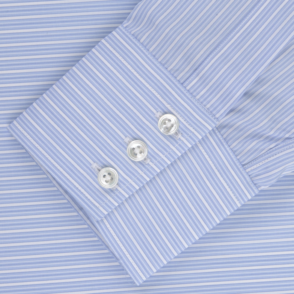 The Turnbull & Asser Light Blue Rich Stripe Shirt features a T&A collar, three-button cuffs, and fine white vertical stripes. Shown neatly laid flat on a white background.