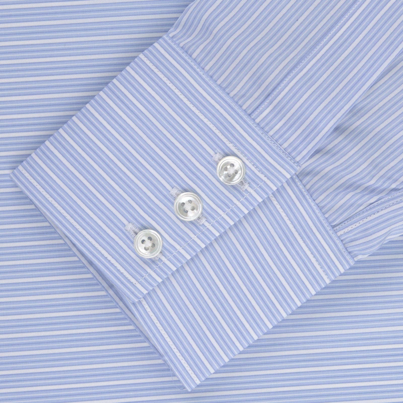 View 2 of product The Turnbull & Asser Light Blue Rich Stripe Shirt features a T&A collar, three-button cuffs, and fine white vertical stripes. Shown neatly laid flat on a white background.