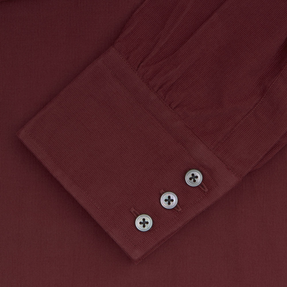 A Turnbull & Asser Burgundy Corduroy Cotton Shirt with a Cambridge collar and 3-button cuffs, neatly folded and displayed on a plain white background.
