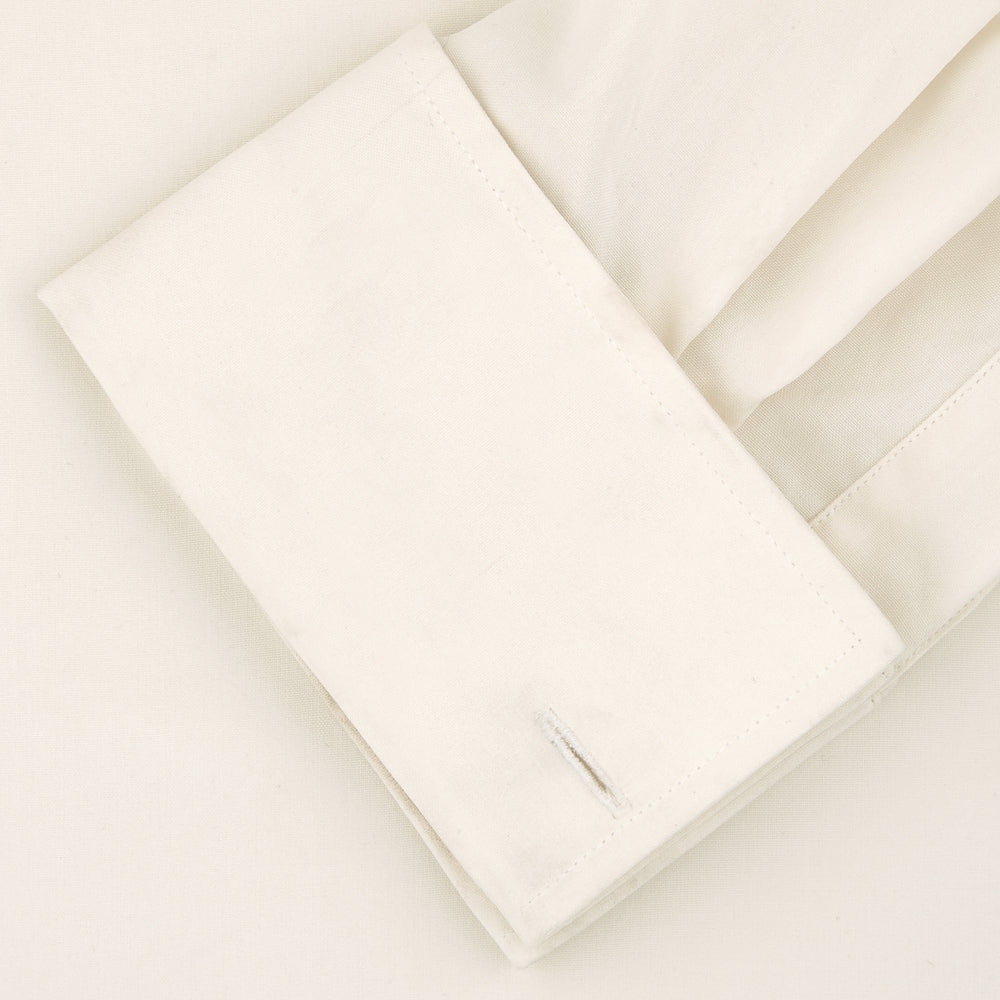 The Turnbull & Asser Tailored Fit Cream Pleated Front Silk Dress Shirt with T&A collar and double cuffs is displayed neatly folded against a light gray background.