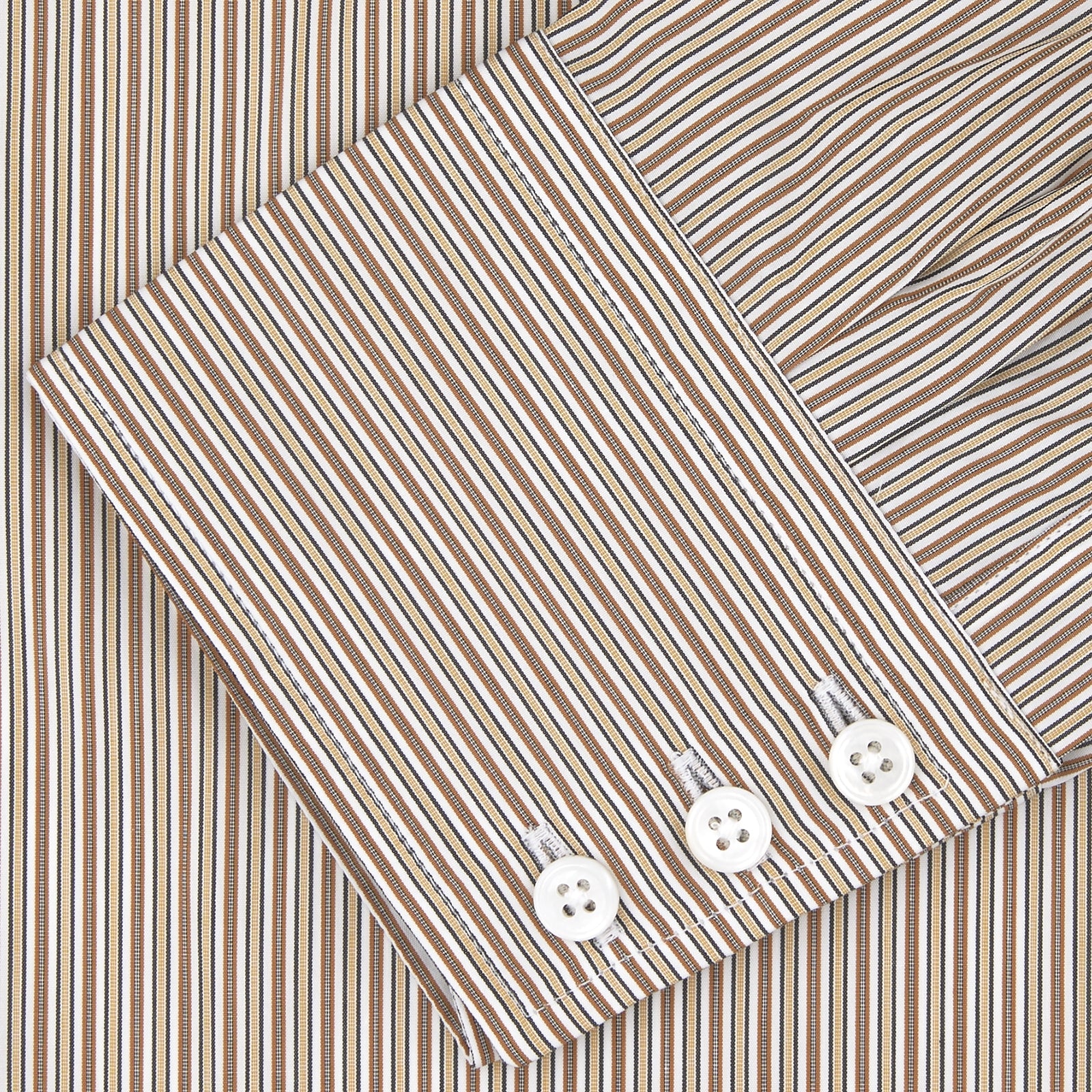 View 4 of product The Turnbull & Asser Tailored Fit Brown Fine Stripe Shirt features a Bury collar, 3-button cuffs, white buttons, and fine brown and white stripes. Made from premium Thomas Mason cotton and shown neatly folded on a plain white background.