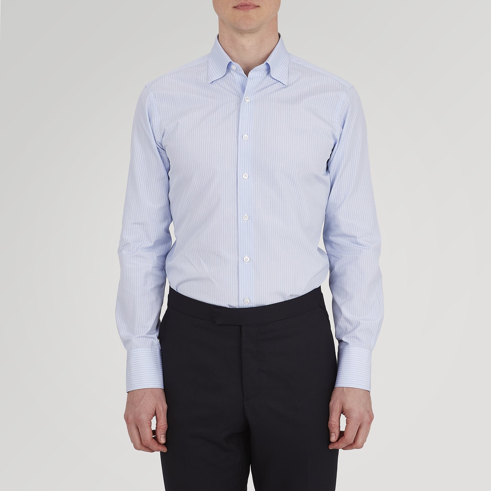 View 4 of product The Turnbull & Asser Tailored Fit Light Blue and White Pinstripe Shirt features a Bury collar and 3-button cuffs, neatly folded and displayed on a plain white background.