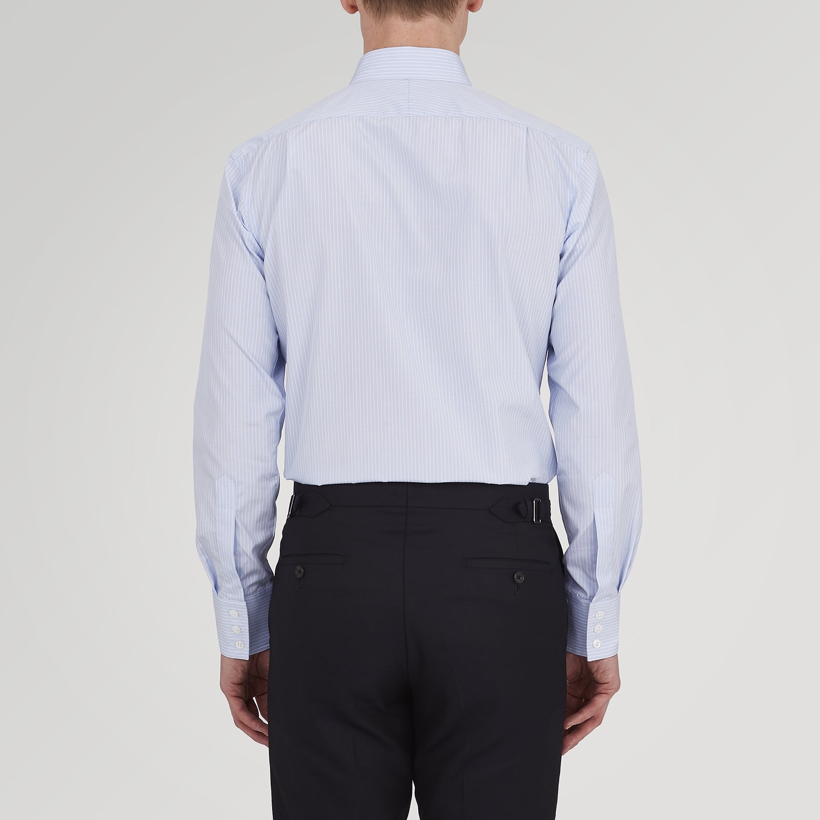 View 5 of product The Turnbull & Asser Tailored Fit Light Blue and White Pinstripe Shirt features a Bury collar and 3-button cuffs, neatly folded and displayed on a plain white background.