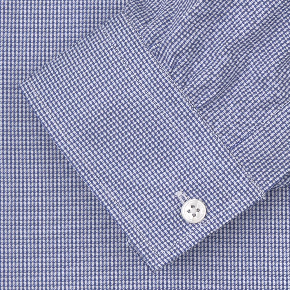 The Turnbull & Asser Weekend Fit Blue Puppytooth Shirt features a Dorset collar, 1-button cuffs, and a blue and white small check pattern. It is neatly folded with white buttons, displayed on a plain white background.