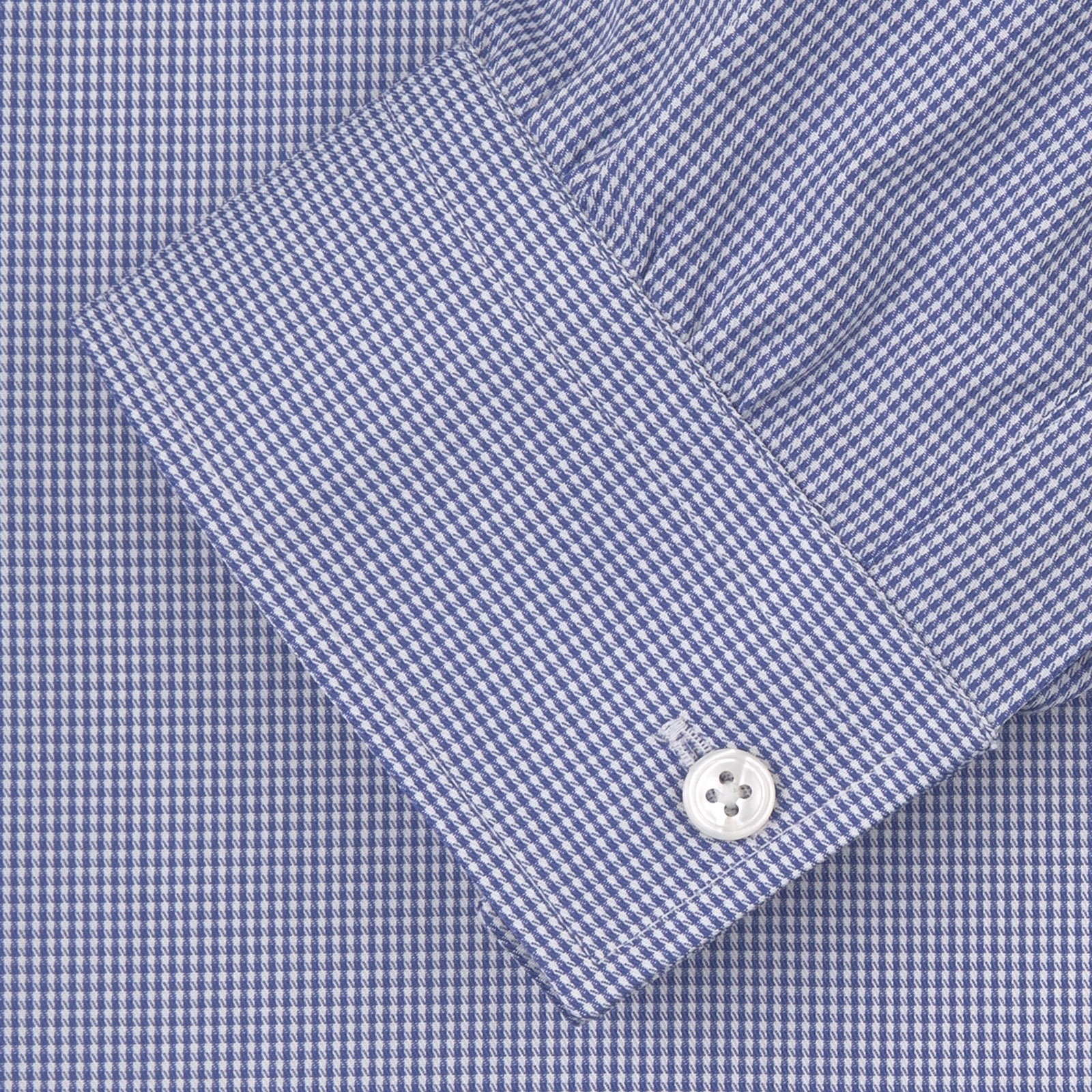 View 2 of product The Turnbull & Asser Weekend Fit Blue Puppytooth Shirt features a Dorset collar, 1-button cuffs, and a blue and white small check pattern. It is neatly folded with white buttons, displayed on a plain white background.