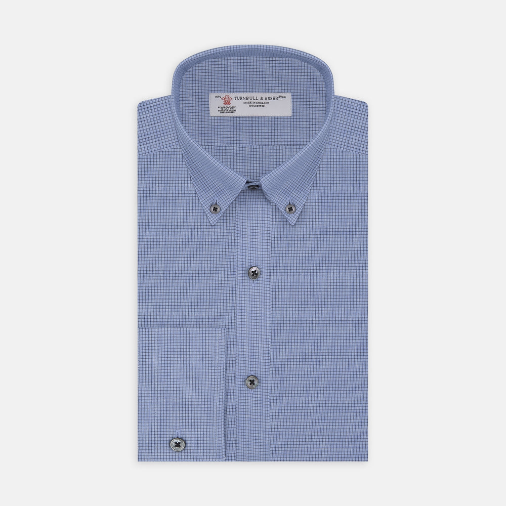 The Turnbull & Asser Weekend Fit Blue Cashmerello Light Shirt features a Dorset collar, 1-button cuffs, subtle check pattern, front pocket, and white buttons—softly folded on a white background.