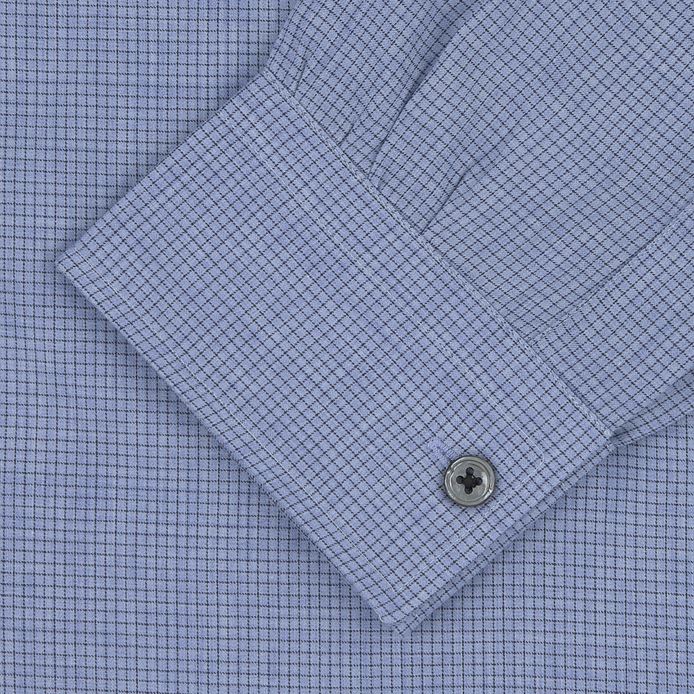 The Turnbull & Asser Weekend Fit Blue Cashmerello Light Shirt features a Dorset collar, 1-button cuffs, subtle check pattern, front pocket, and white buttons—softly folded on a white background.