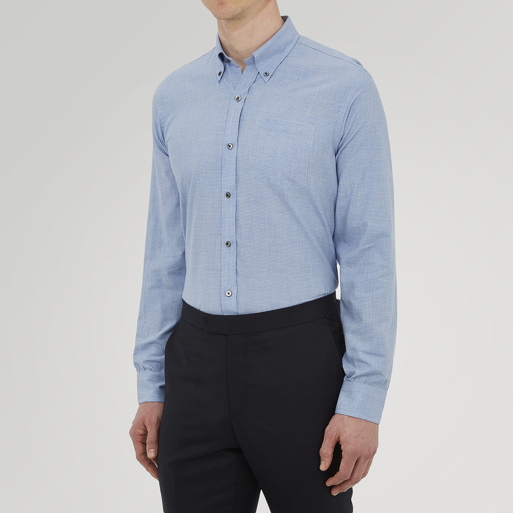 The Turnbull & Asser Weekend Fit Blue Cashmerello Light Shirt features a Dorset collar, 1-button cuffs, subtle check pattern, front pocket, and white buttons—softly folded on a white background.