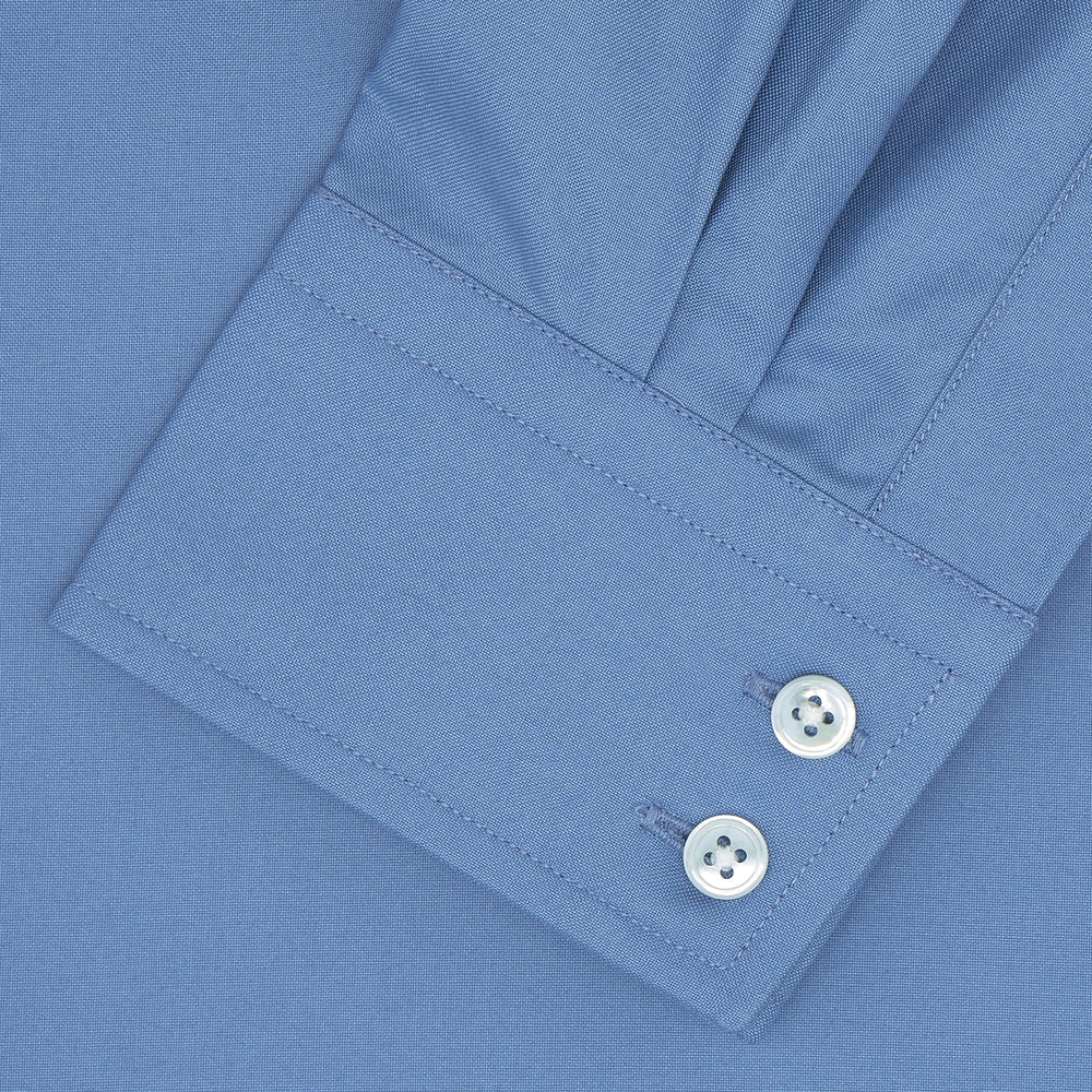 The Turnbull & Asser Tailored Fit Deep Blue Cotton Shirt features a classic Kent collar and 2-button cuffs, shown neatly folded with white buttons against a plain white background.