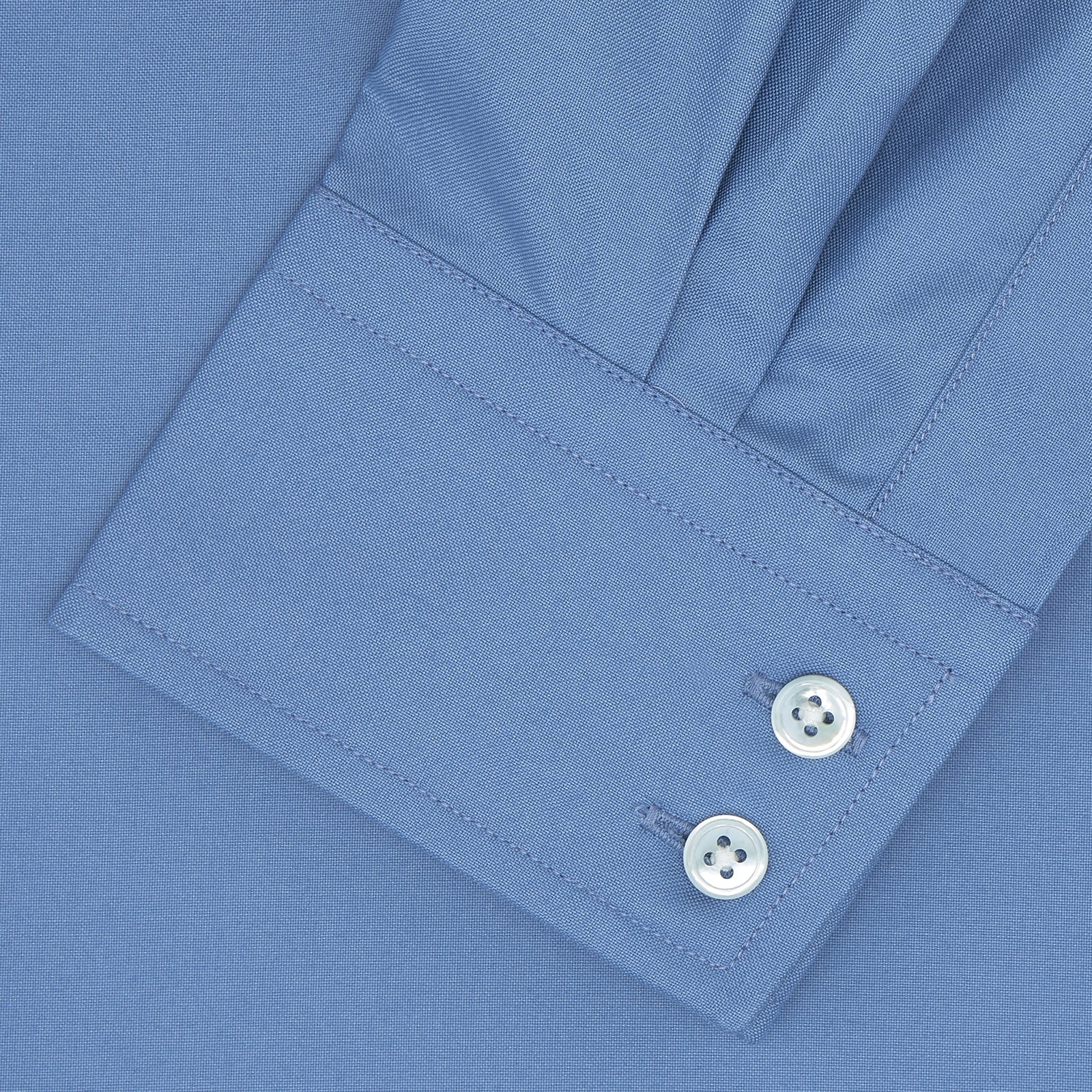 View 2 of product The Turnbull & Asser Tailored Fit Deep Blue Cotton Shirt features a classic Kent collar and 2-button cuffs, shown neatly folded with white buttons against a plain white background.