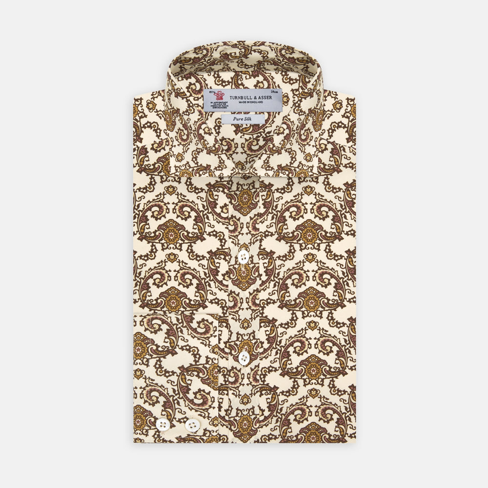 The Turnbull & Asser Tailored Fit Cream Jagger Print Silk Shirt features a Kent collar, 2-button cuffs, and an intricate brown and gold print on cream silk for timeless elegance.