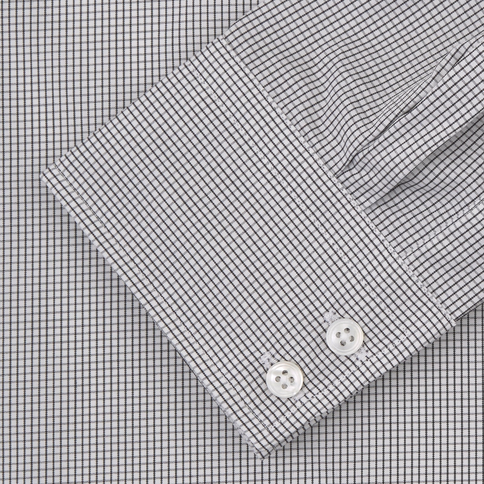 View 2 of product A neatly folded Turnbull & Asser Tailored Fit Grey and White Small Check Shirt with a Kent collar and 2-button cuffs is shown, featuring its brand label inside the collar.