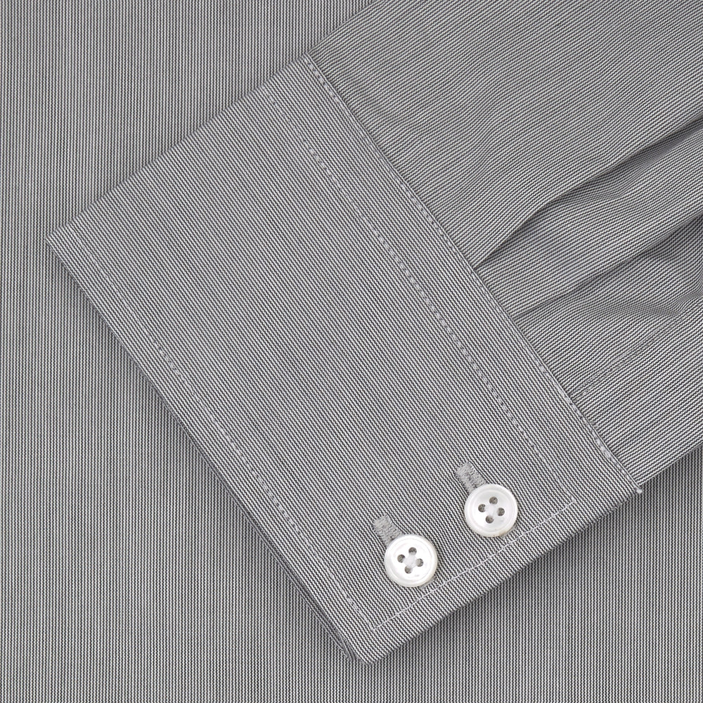 Turnbull & Asser’s Tailored Fit Grey End-On-End Shirt features a classic Kent collar, white buttons, and 2-button cuffs. This long-sleeved shirt is displayed neatly folded against a plain white background.