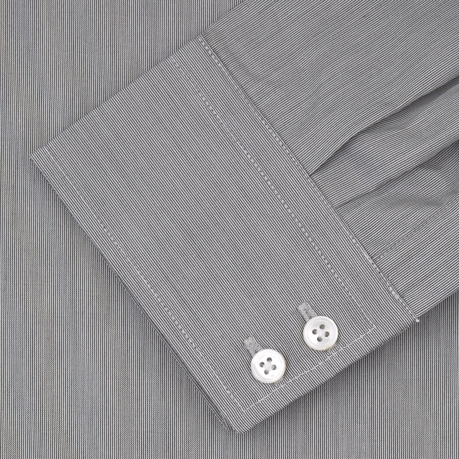 View 2 of product Turnbull & Asser’s Tailored Fit Grey End-On-End Shirt features a classic Kent collar, white buttons, and 2-button cuffs. This long-sleeved shirt is displayed neatly folded against a plain white background.