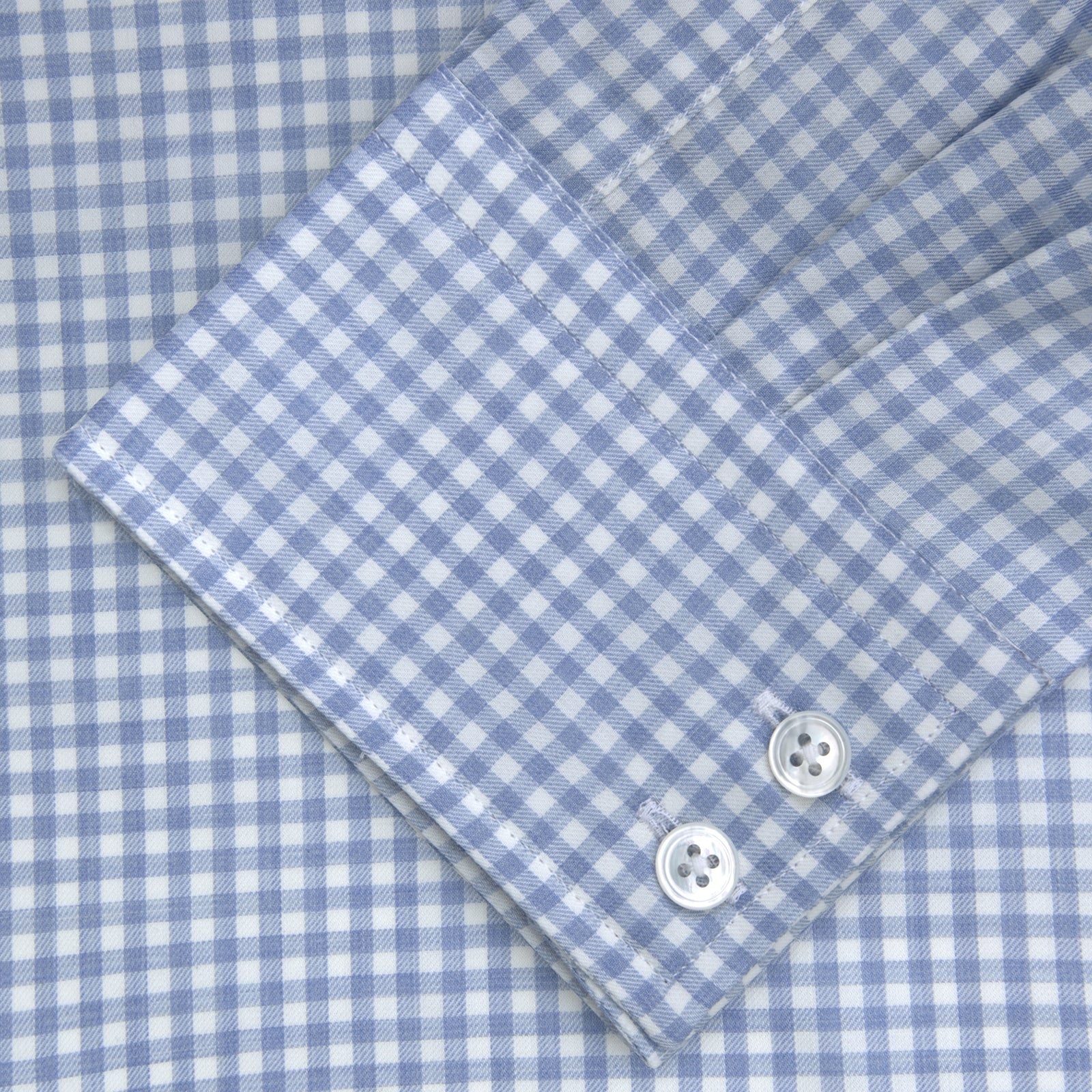 View 2 of product The Turnbull & Asser Tailored Fit Light Blue Gingham Shirt features a Kent collar, 2-button cuffs, and a small blue-and-white checkered pattern, shown on a white background.