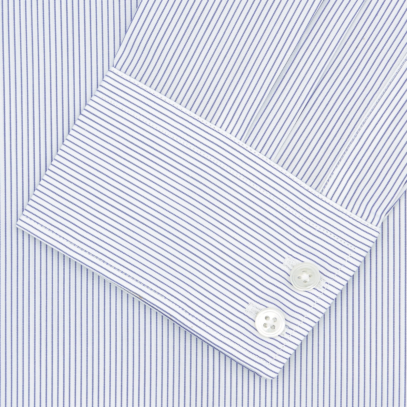 View 2 of product The Turnbull & Asser Tailored Fit Blue and White Fine Stripe Shirt features a Kent collar and 2-button cuffs, shown neatly folded against a plain white background.