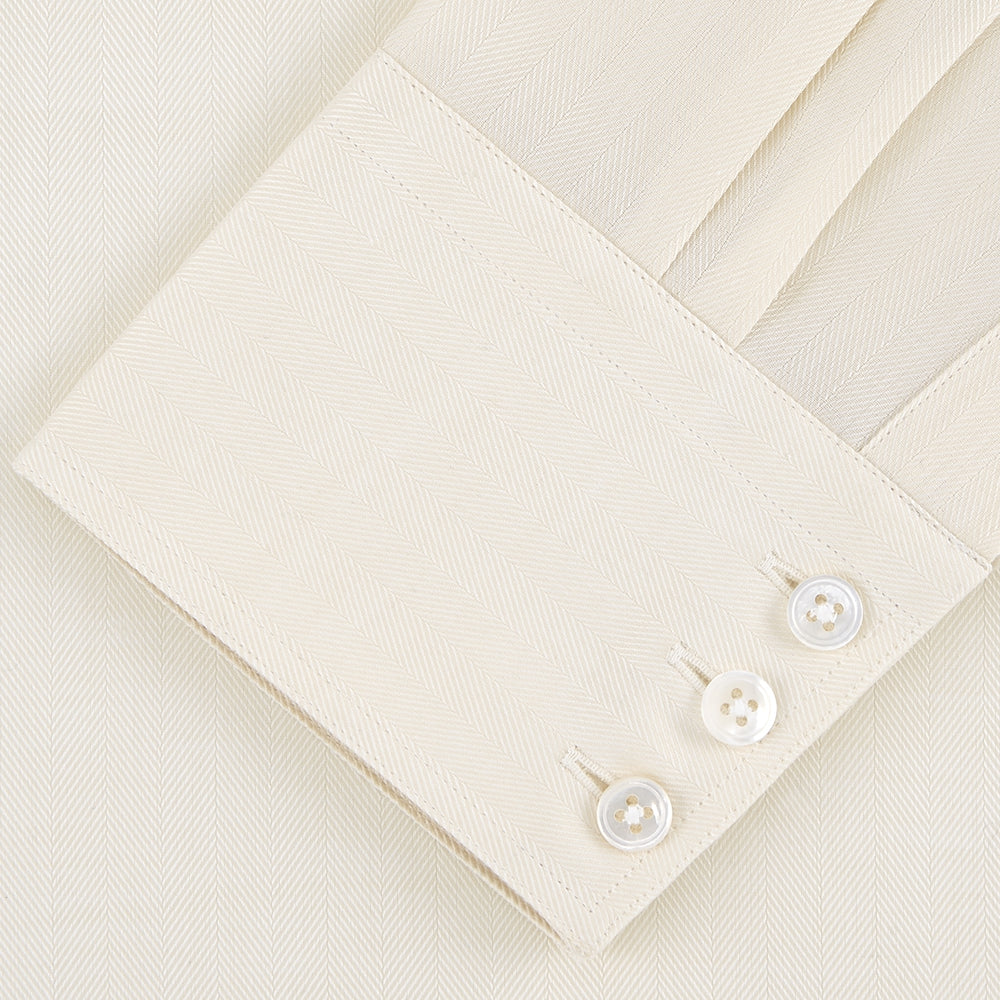 The Turnbull & Asser Weekend Fit Cream Herringbone Western Shirt features a Norfolk collar, button cuffs, and chest pockets, elegantly folded and displayed on a plain white background.