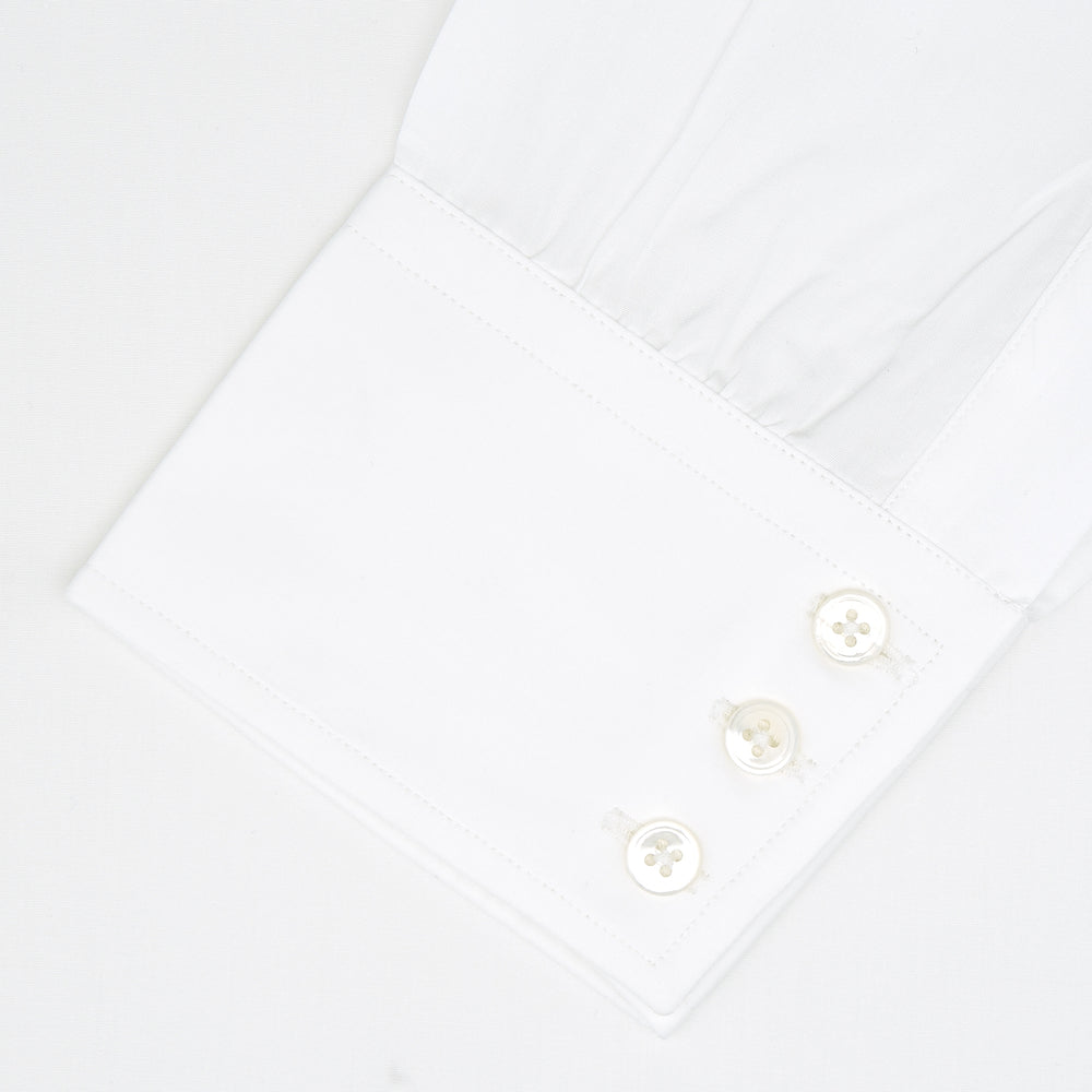 A neatly folded white Turnbull & Asser shirt, tailored fit with a Kent collar and 3BC PLA details, pearl-like buttons, and signature cuffs, is displayed against a light grey background. The label reads Turnbull & Asser.