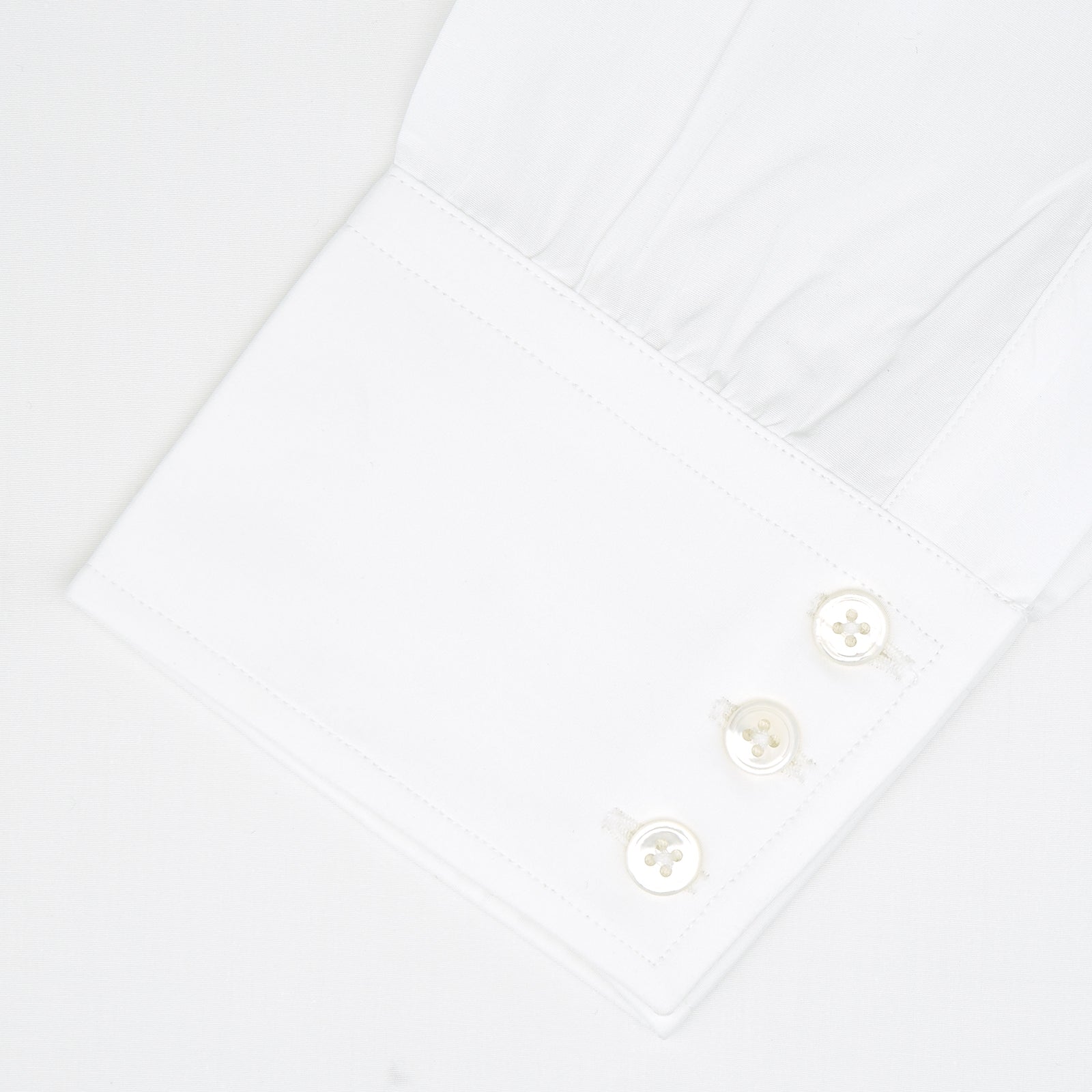 View 2 of product A neatly folded white Turnbull & Asser shirt, tailored fit with a Kent collar and 3BC PLA details, pearl-like buttons, and signature cuffs, is displayed against a light grey background. The label reads Turnbull & Asser.