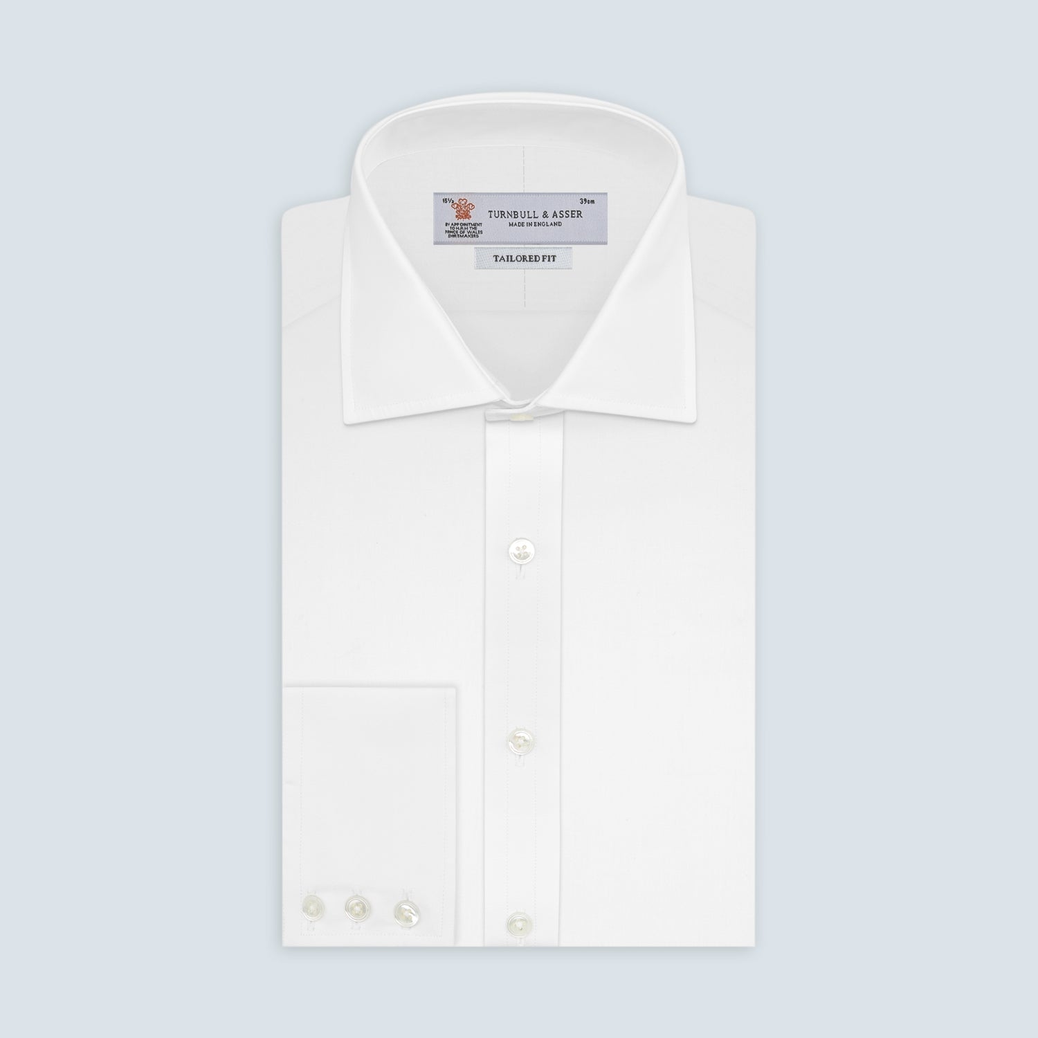 View 1 of product A neatly folded white Turnbull & Asser shirt, tailored fit with a Kent collar and 3BC PLA details, pearl-like buttons, and signature cuffs, is displayed against a light grey background. The label reads Turnbull & Asser.
