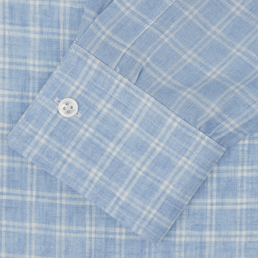 The Turnbull & Asser Weekend Fit Blue Plaid Linen Shirt features a white check pattern, Derby collar, long sleeves with 1-button cuffs, single chest pocket, and button-up front, shown against a white background.