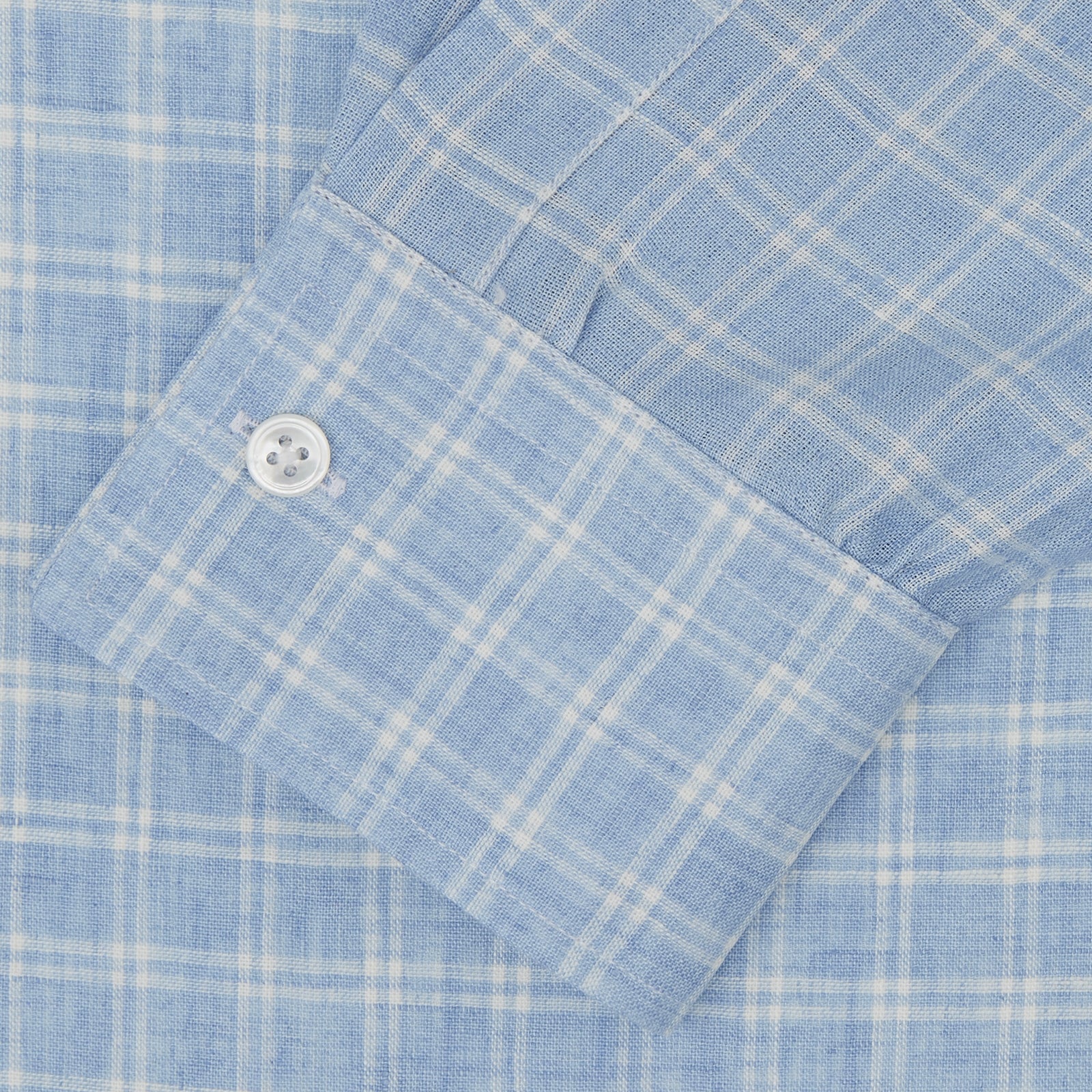 View 2 of product The Turnbull & Asser Weekend Fit Blue Plaid Linen Shirt features a white check pattern, Derby collar, long sleeves with 1-button cuffs, single chest pocket, and button-up front, shown against a white background.