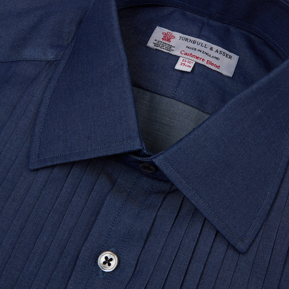A neatly folded Turnbull & Asser Dark Blue Denim-Cashmere Dress Shirt with T&A collar and 3-button cuffs, showcased on a plain light background, offers a refined formal alternative.