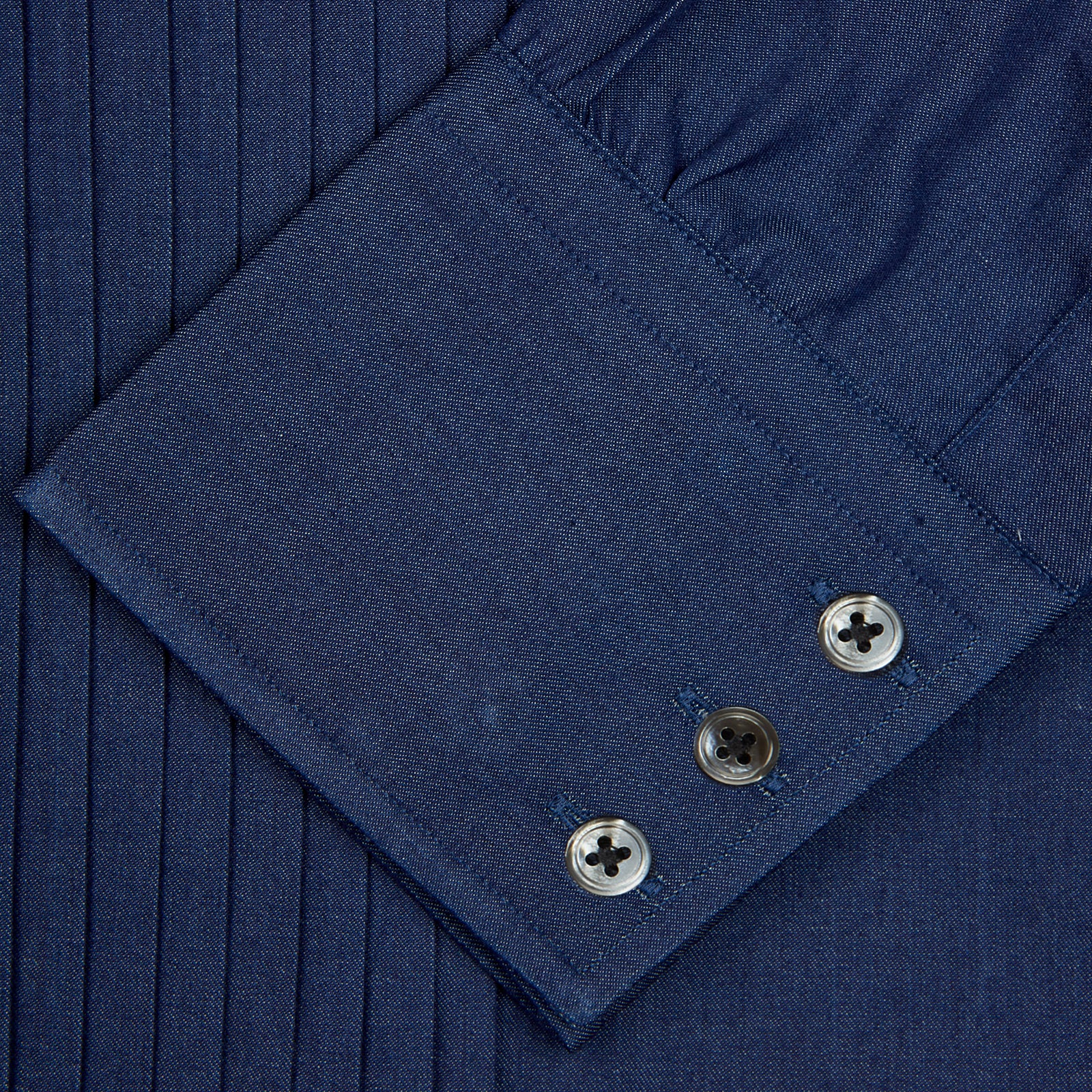 View 5 of product A neatly folded Turnbull & Asser Dark Blue Denim-Cashmere Dress Shirt with T&A collar and 3-button cuffs, showcased on a plain light background, offers a refined formal alternative.