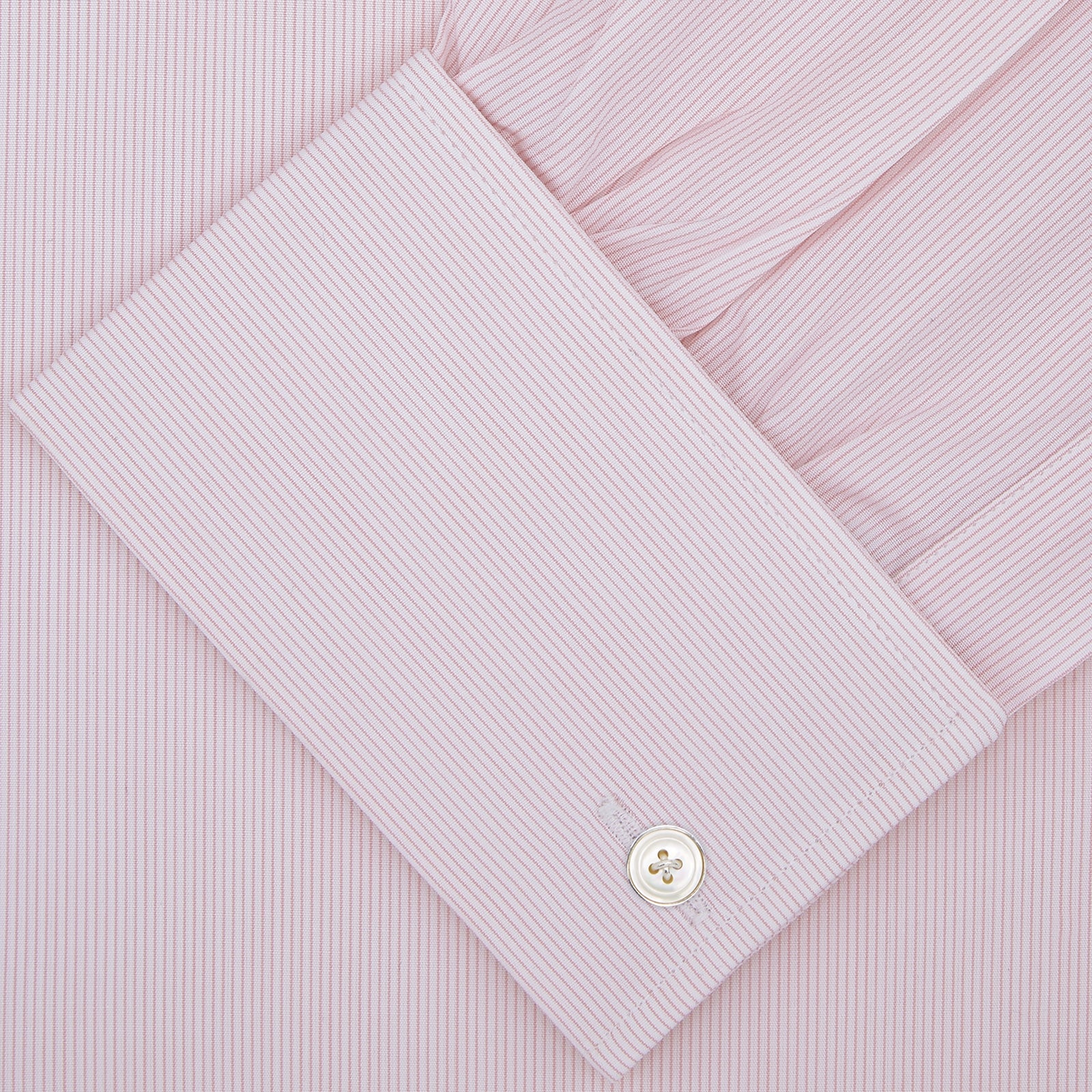 View 4 of product The Turnbull & Asser Pink Hairline Stripe Cotton Shirt features a T&A collar, double cuffs, neat vertical stripes, white buttons, and a chest pocket—perfect for the office. Shown neatly folded on a plain white background.