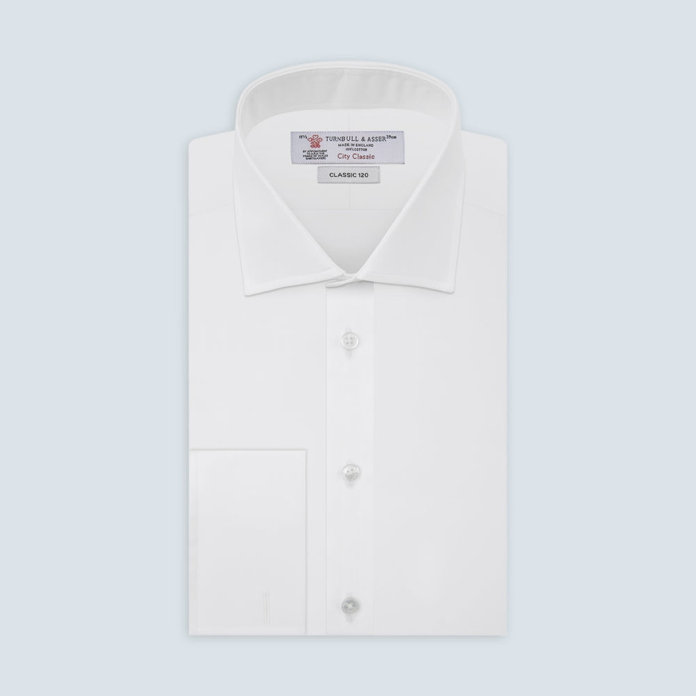 The Turnbull & Asser Two-Fold 120 White Cotton Shirt features long sleeves, a regent collar, double cuffs, and white buttons, neatly displayed against a light blue background.