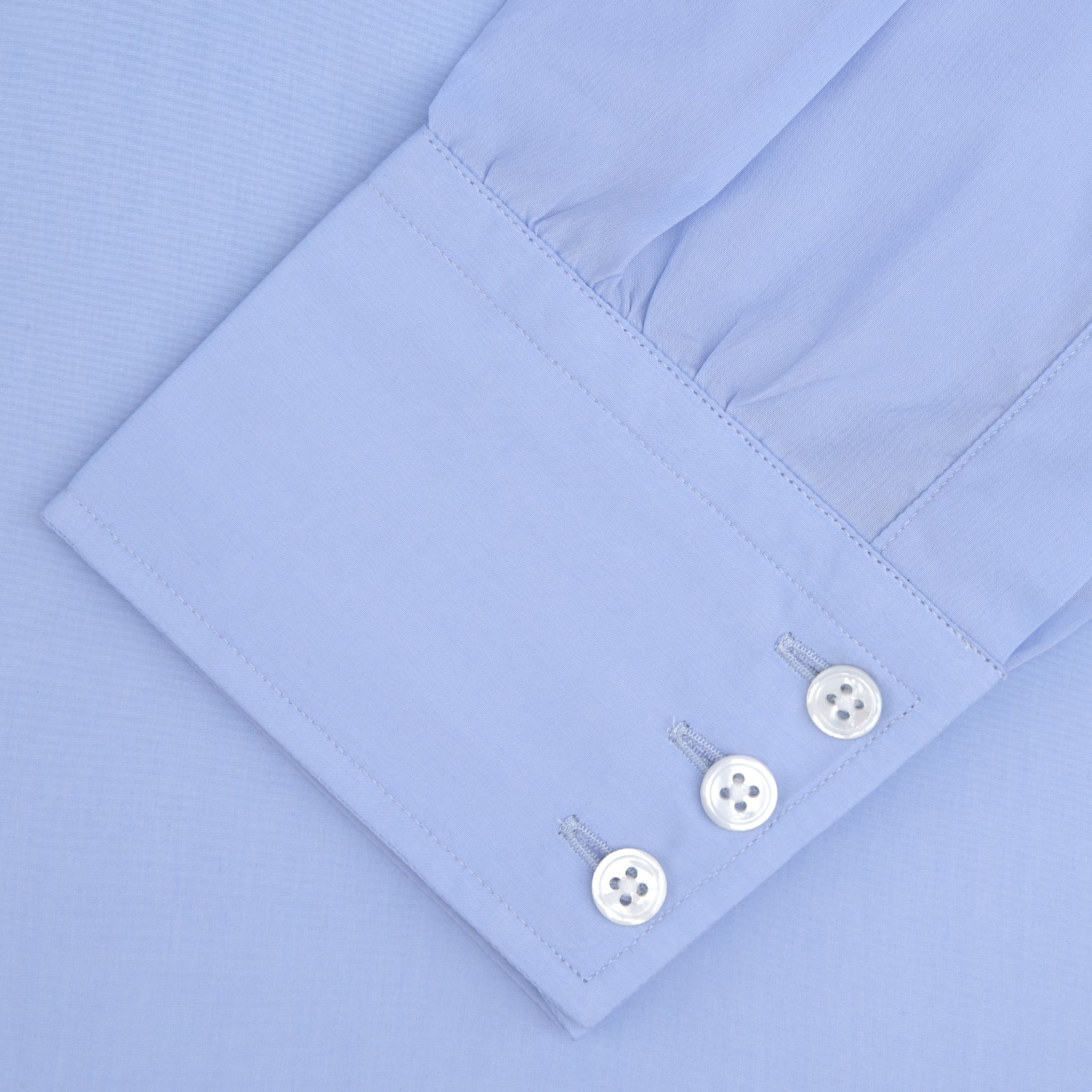 View 4 of product The Turnbull & Asser Two-Fold 200 Blue Cotton Shirt features a T&A collar, 3-button cuffs, and white buttons—a refined men's dress shirt displayed on a plain white background.