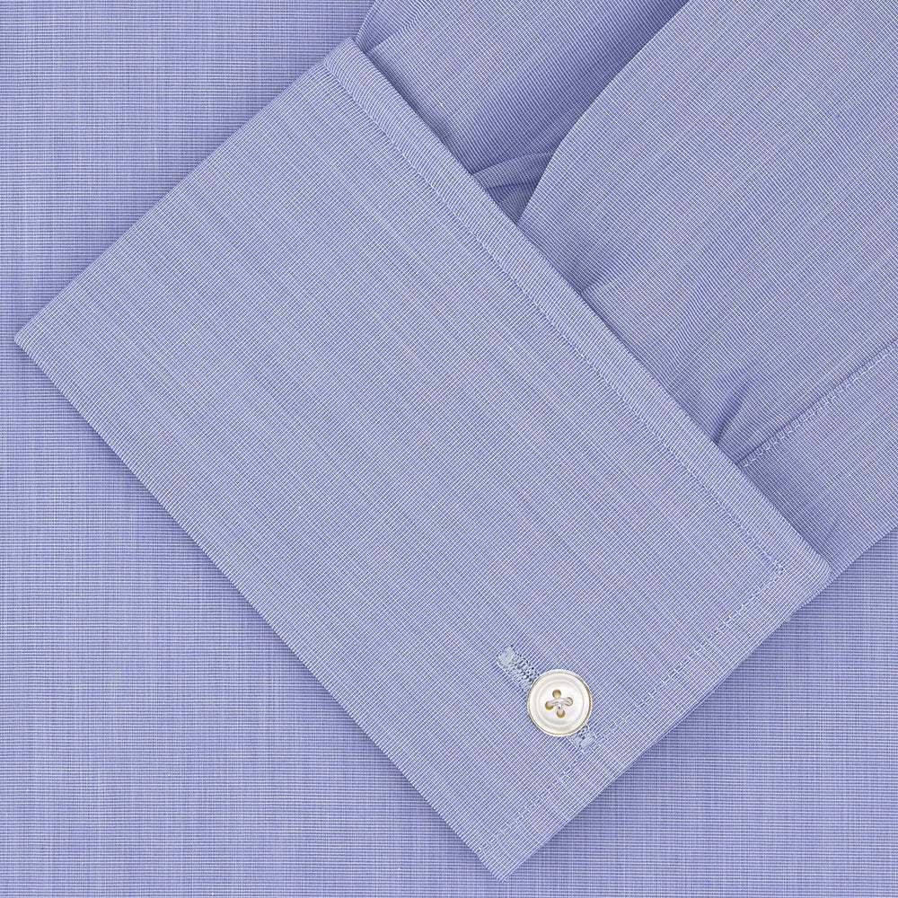 A neatly folded dark blue Sea Island quality cotton shirt by Turnbull & Asser, featuring a T&A collar, double cuffs, and white buttons, is displayed against a plain white background.