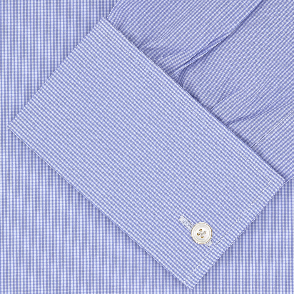 The Turnbull & Asser Blue Fine Check Sea Island Quality Cotton Shirt features a Regent collar, double cuffs, a subtle checkered pattern, and white buttons, displayed neatly folded on a white background.