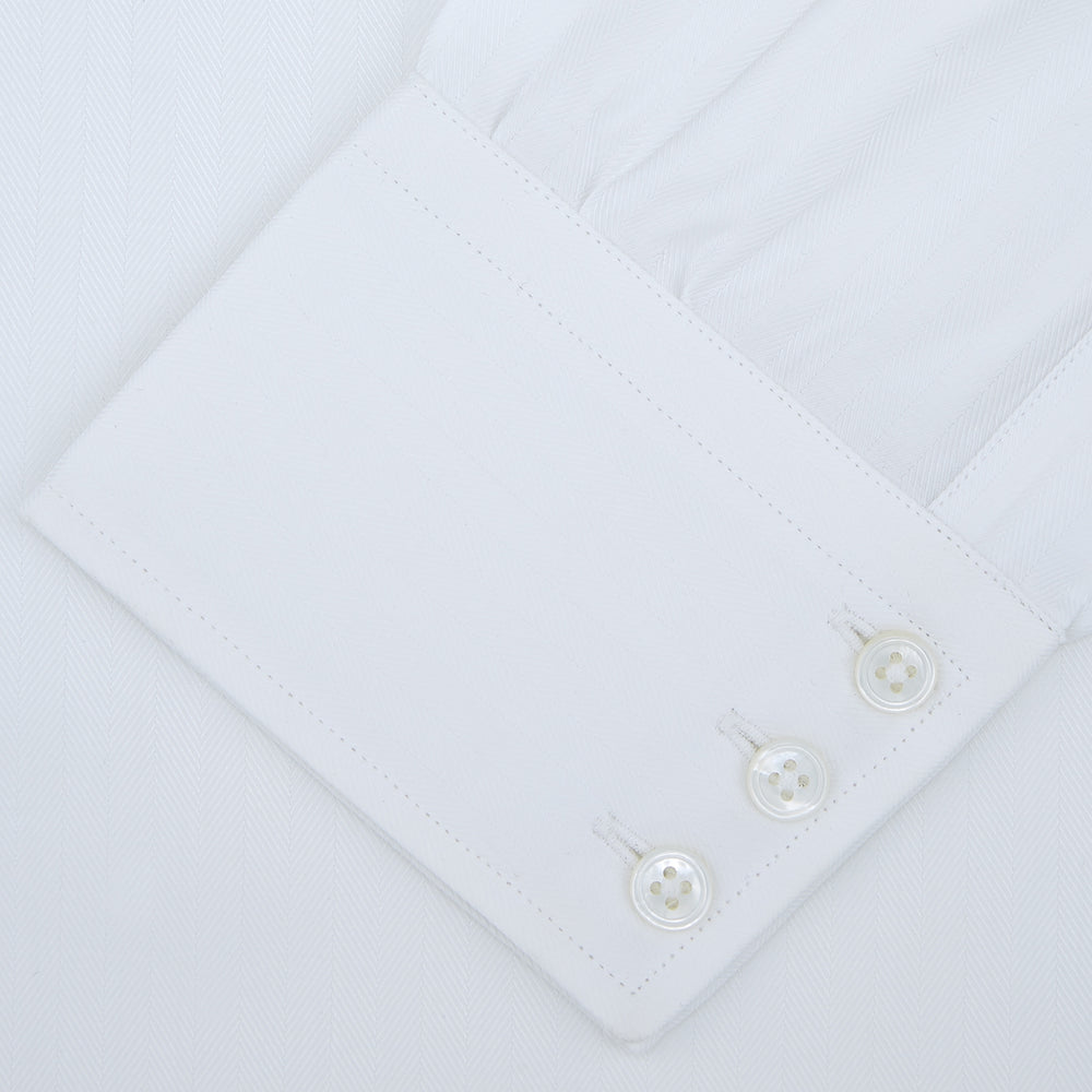 A Turnbull & Asser White Self-On-Self Herringbone Sea Island Quality Cotton Shirt with a Regent collar and 3-button cuffs, neatly folded and displayed on a light grey background.
