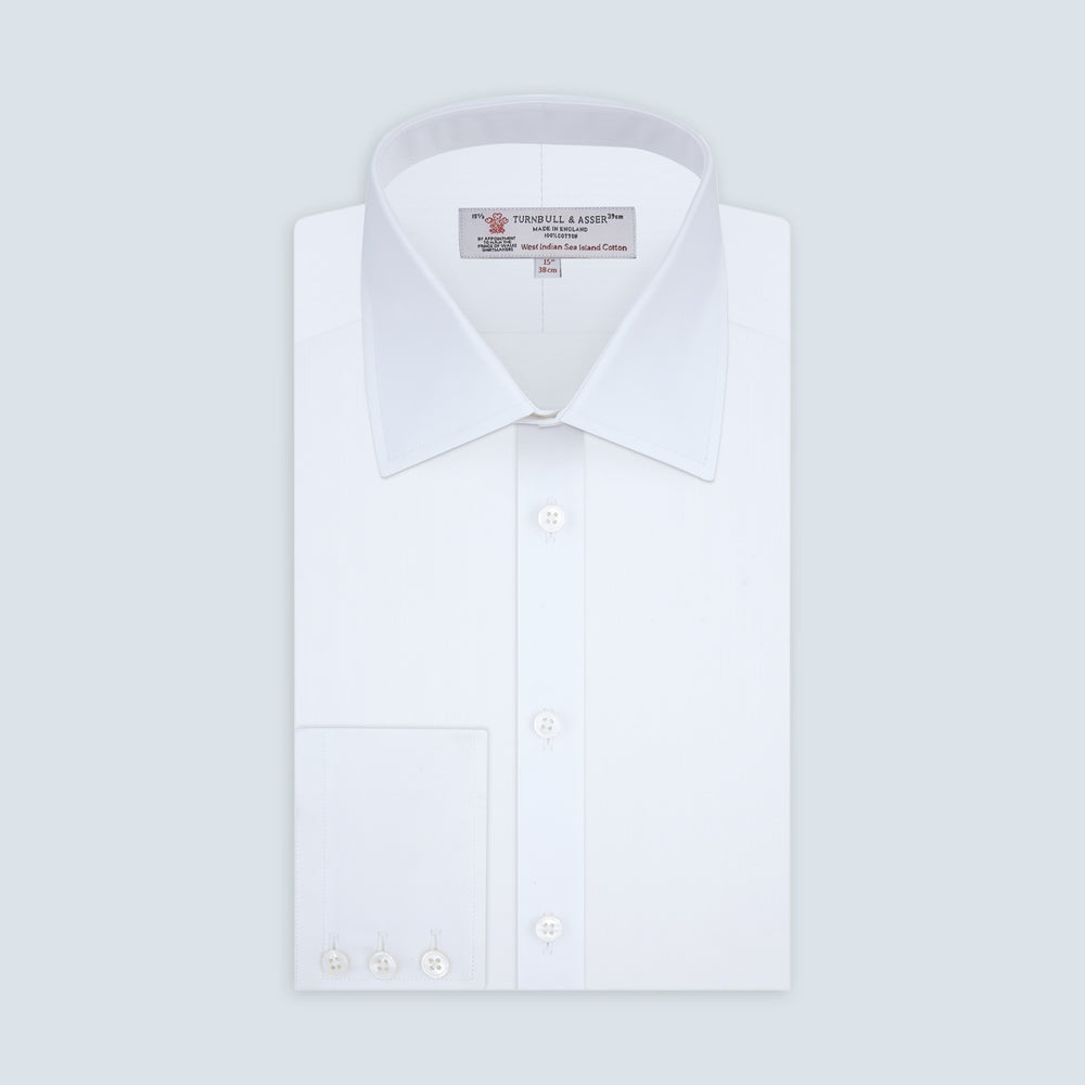A Turnbull & Asser White Self-On-Self Herringbone Sea Island Quality Cotton Shirt with a Regent collar and 3-button cuffs, neatly folded and displayed on a light grey background.