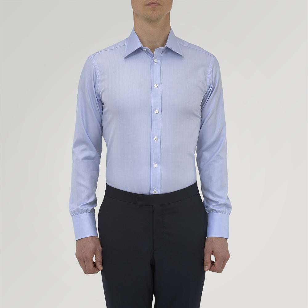 The Blue Herringbone Sea Island Quality Cotton Shirt by Turnbull & Asser features a T&A collar, 3-button cuffs, and is crafted from luxurious cotton. The shirt is displayed neatly folded on a plain white background.