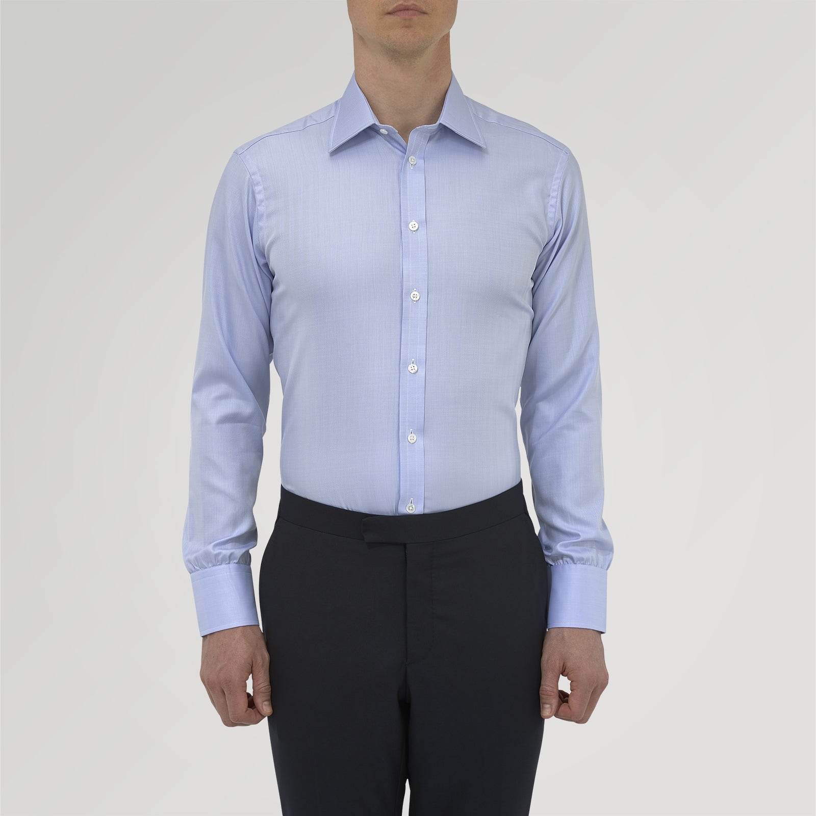 View 2 of product The Blue Herringbone Sea Island Quality Cotton Shirt by Turnbull & Asser features a T&A collar, 3-button cuffs, and is crafted from luxurious cotton. The shirt is displayed neatly folded on a plain white background.