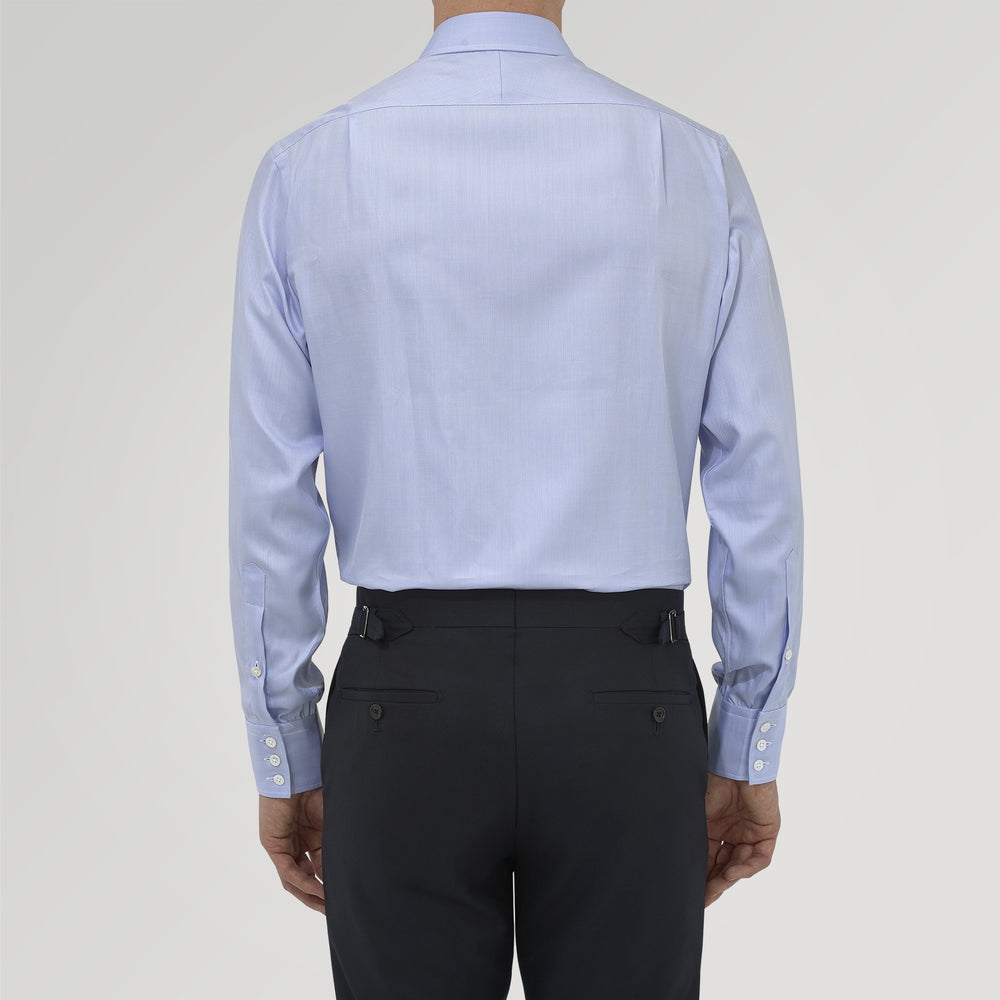 The Blue Herringbone Sea Island Quality Cotton Shirt by Turnbull & Asser features a T&A collar, 3-button cuffs, and is crafted from luxurious cotton. The shirt is displayed neatly folded on a plain white background.