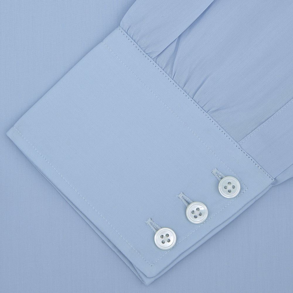 The Turnbull & Asser Blue Sea Island Quality Cotton Shirt features a Dr. No collar and button cuffs, crafted from fine cotton and shown neatly folded on a plain white background.