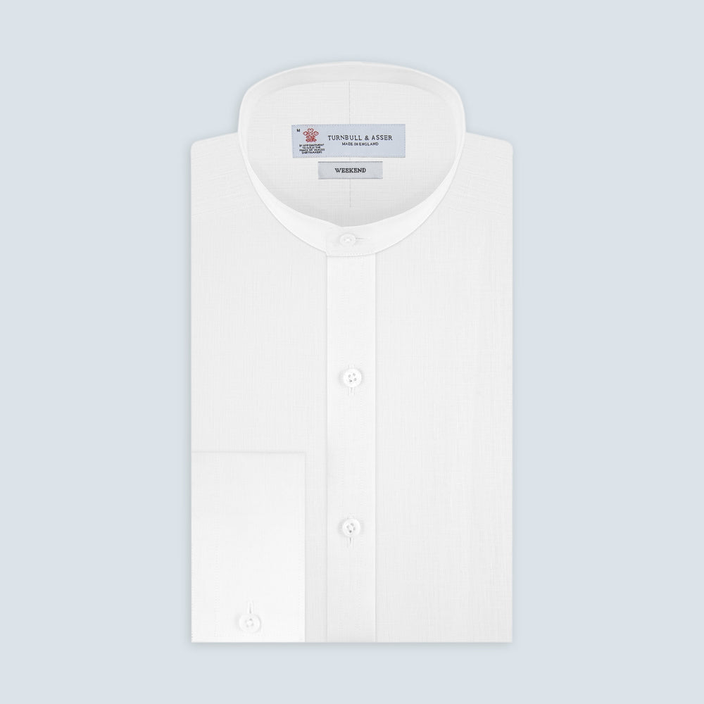 The Weekend Fit Cream Linen Shirt by Turnbull & Asser features a stand collar, button front, and 1-button cuff. Displayed neatly folded, the cream linen shirt highlights its refined craftsmanship against a light grey background.
