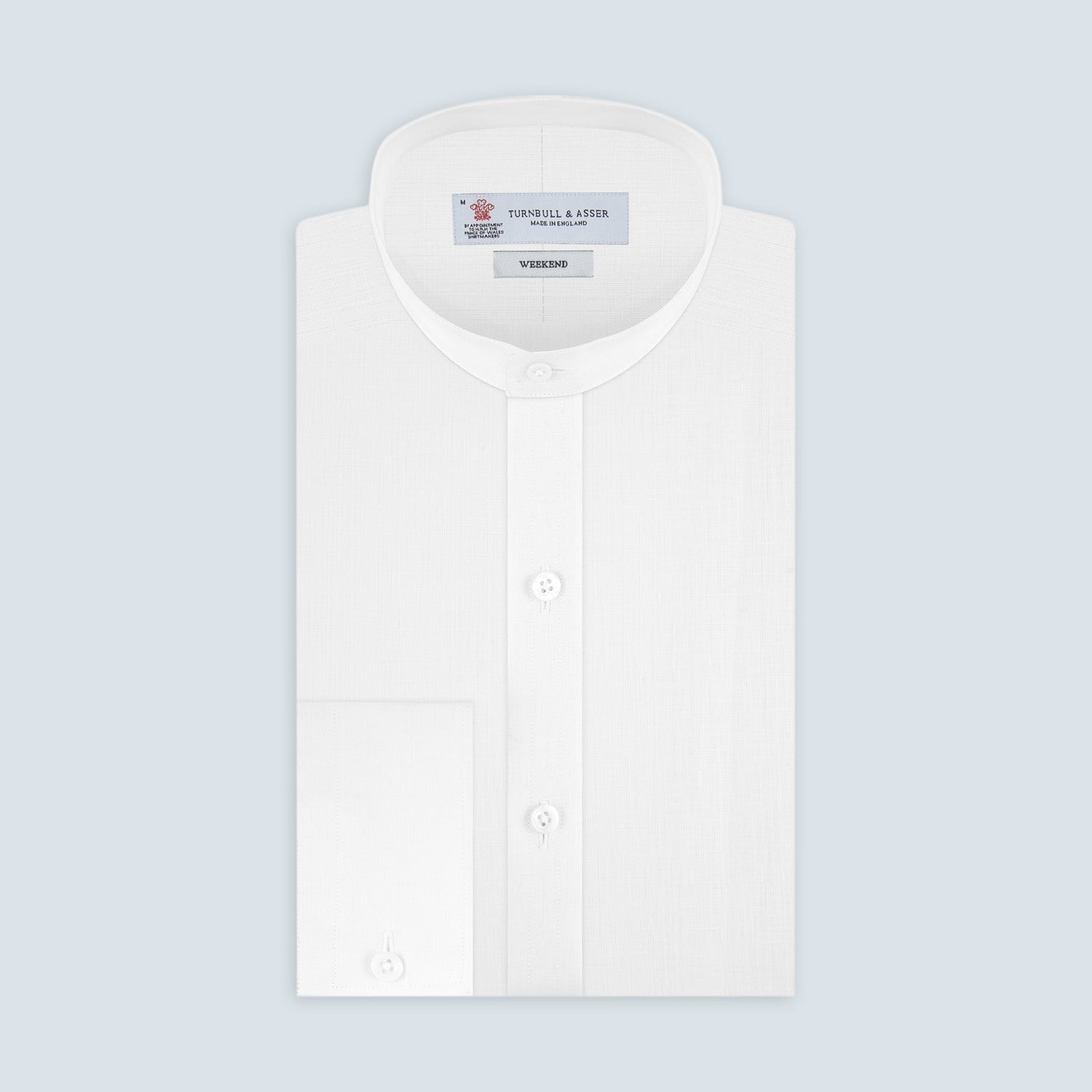 View 1 of product The Weekend Fit Cream Linen Shirt by Turnbull & Asser features a stand collar, button front, and 1-button cuff. Displayed neatly folded, the cream linen shirt highlights its refined craftsmanship against a light grey background.