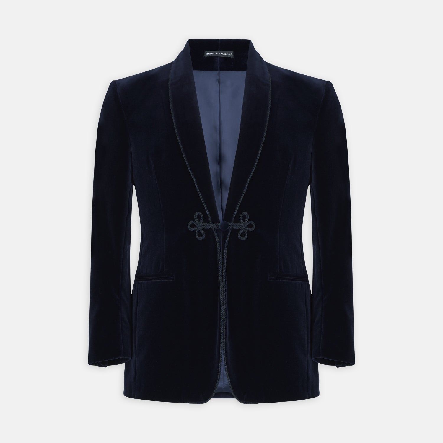 View 1 of product Turnbull & Asser's MSMJ004-ZCS002 "Fergus" velvet smoking jacket in navy features a shawl collar, single decorative knot closure, and two front pockets, shown against a white background.