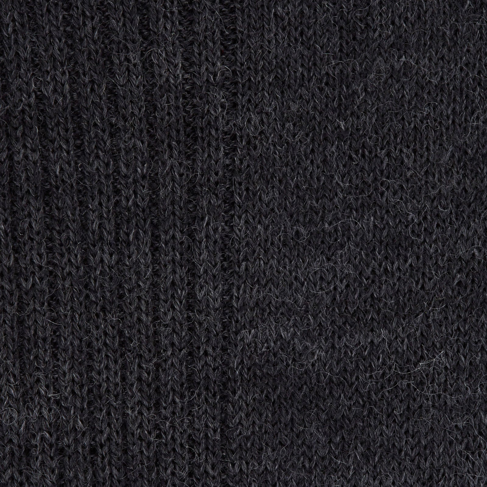 View 2 of product A single Charcoal Mid-Length Merino Wool Sock by Turnbull & Asser stands upright on a light gray background, its dark ribbed fabric and angled foot showcased.