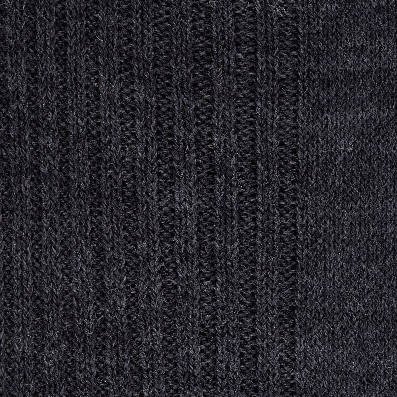 View 2 of product The Turnbull & Asser Dark Grey Mid-Length Merino Wool Sock, ideal as a men’s dress sock, is showcased upright against a plain light gray background.