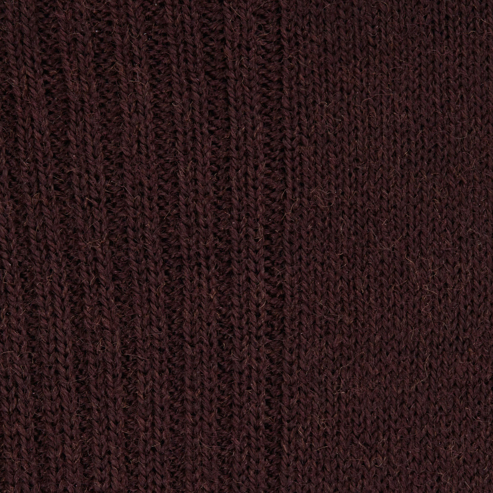 A single maroon mid-length Merino wool sock from Turnbull & Asser stands upright on a plain light gray background, highlighting its ribbed texture.